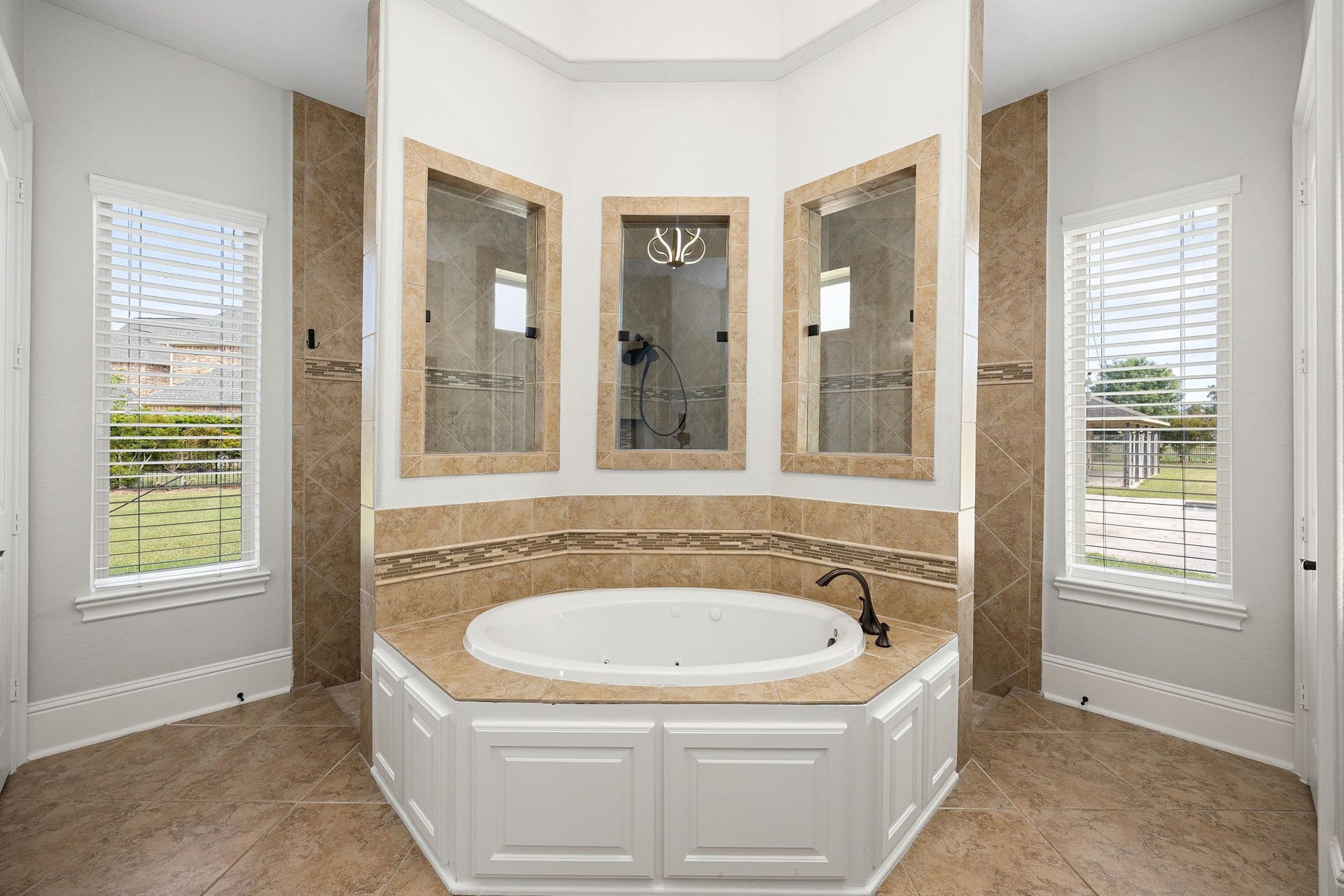 5127 Beekman Drive, Missouri City, TX 77459 The jetted soaking tub is a showpiece unto itself, enveloped in artisan tile work and bathed in natural light.