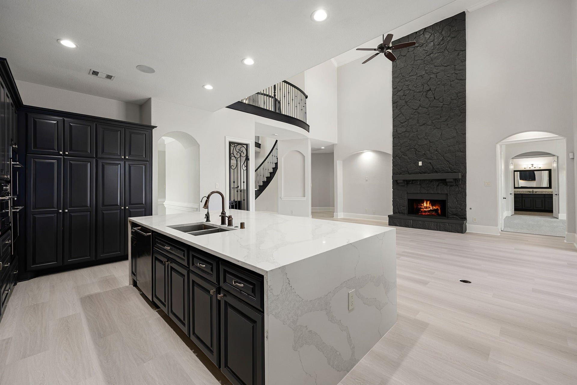 5127 Beekman Drive, Missouri City, TX 77459 The open-concept design connects the kitchens oversized island to the living areas stone fireplace, with a staircase and overlook adding architectural interest.