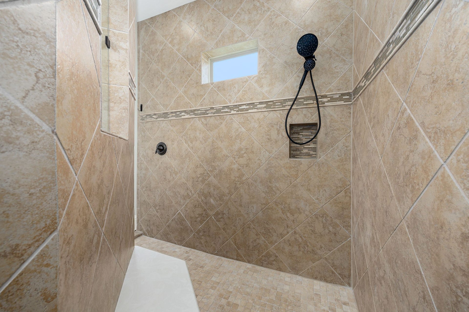 5127 Beekman Drive, Missouri City, TX 77459 An oversized walk-in shower completes the ensuite, finished with designer tile and a built-in niche for an elevated everyday experience.