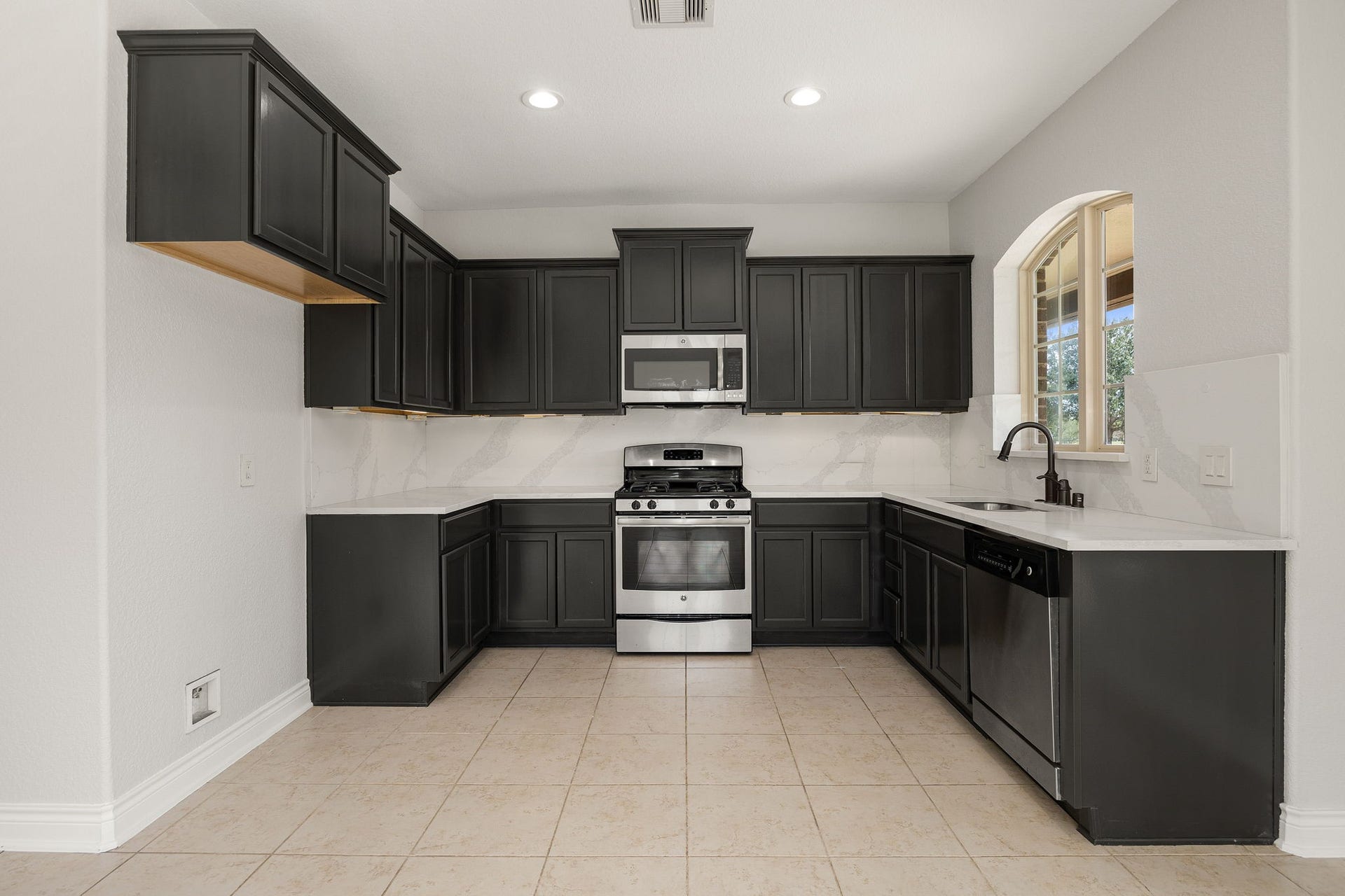 5127 Beekman Drive, Missouri City, TX 77459 The kitchen offers sleek dark cabinetry, a stainless gas range, microwave, and dishwasher, every comfort of home in this private guest suite.