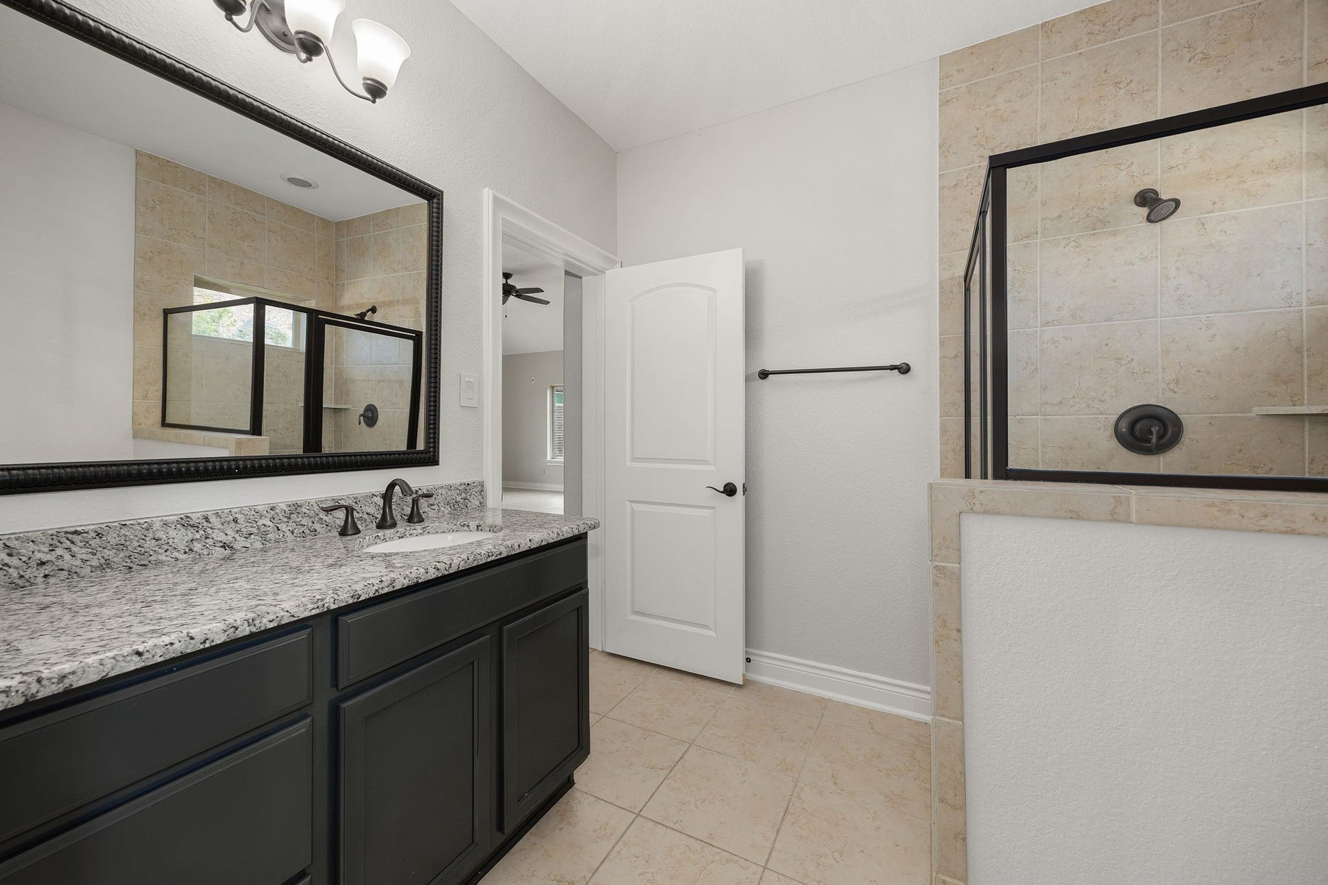 5127 Beekman Drive, Missouri City, TX 77459 The full bathroom features a granite-top vanity and a glass-enclosed walk-in shower, offering guests a comfortable, private retreat.