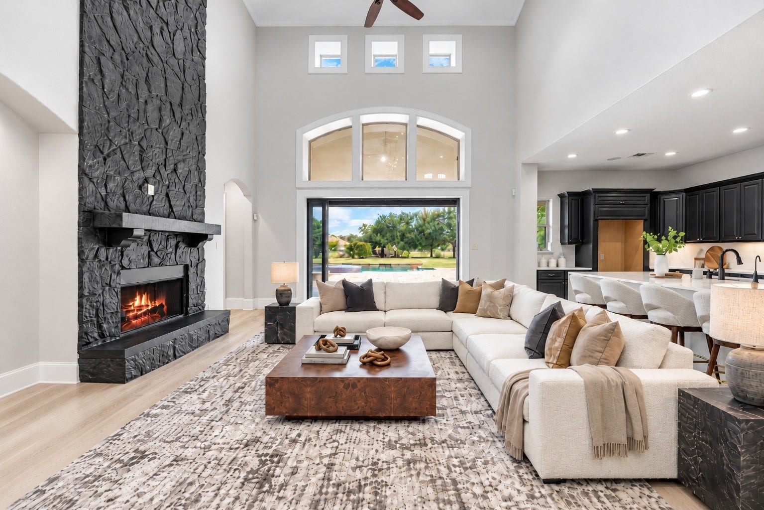 5127 Beekman Drive, Missouri City, TX 77459 The living area impresses with a dramatic two-story stone fireplace and oversized windows, opening seamlessly to the backyard through sliding glass doors. Virtually staged.