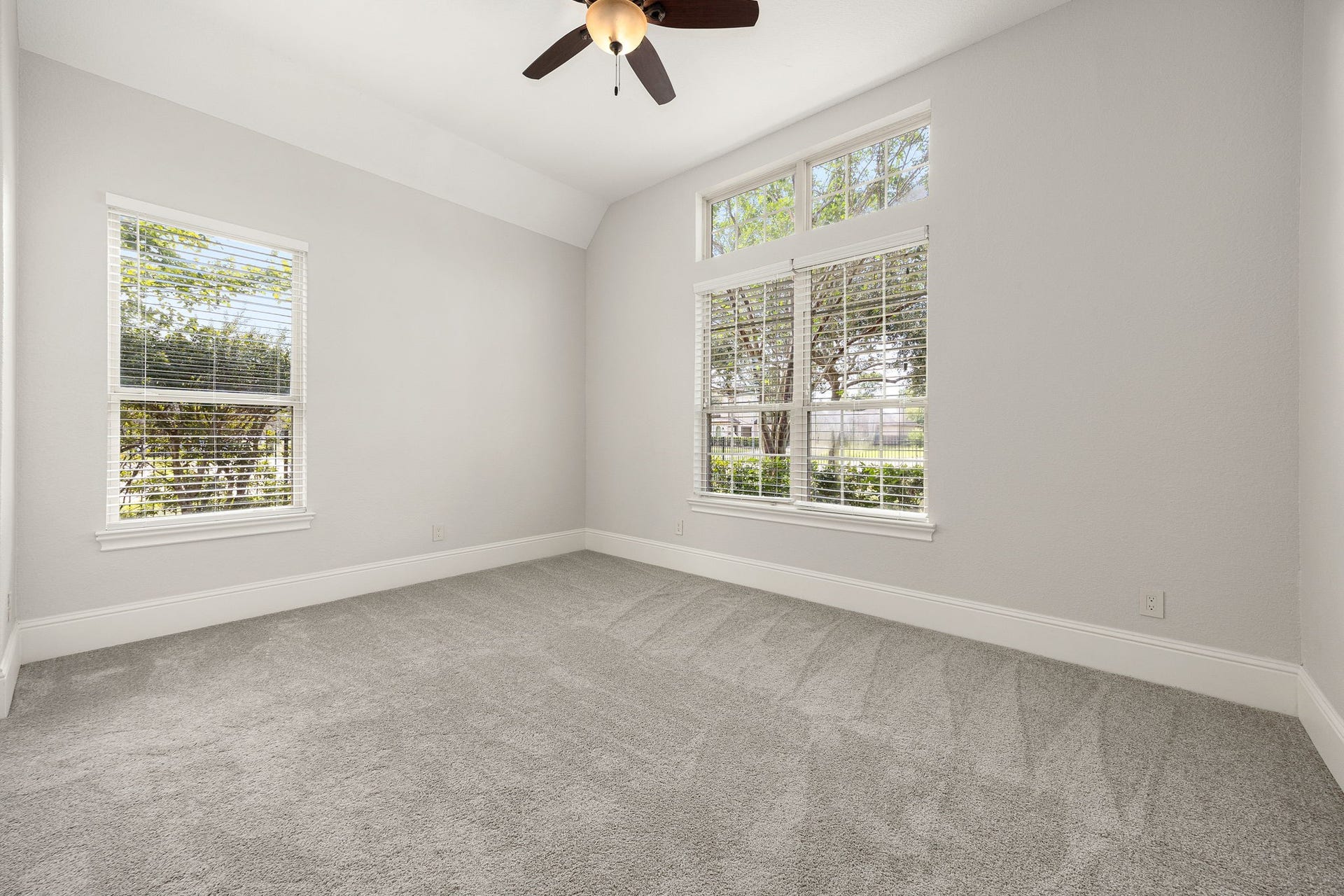 5127 Beekman Drive, Missouri City, TX 77459 A beautifully appointed secondary bedroom downstairs offers soaring vaulted ceilings and abundant natural light through oversized windows.