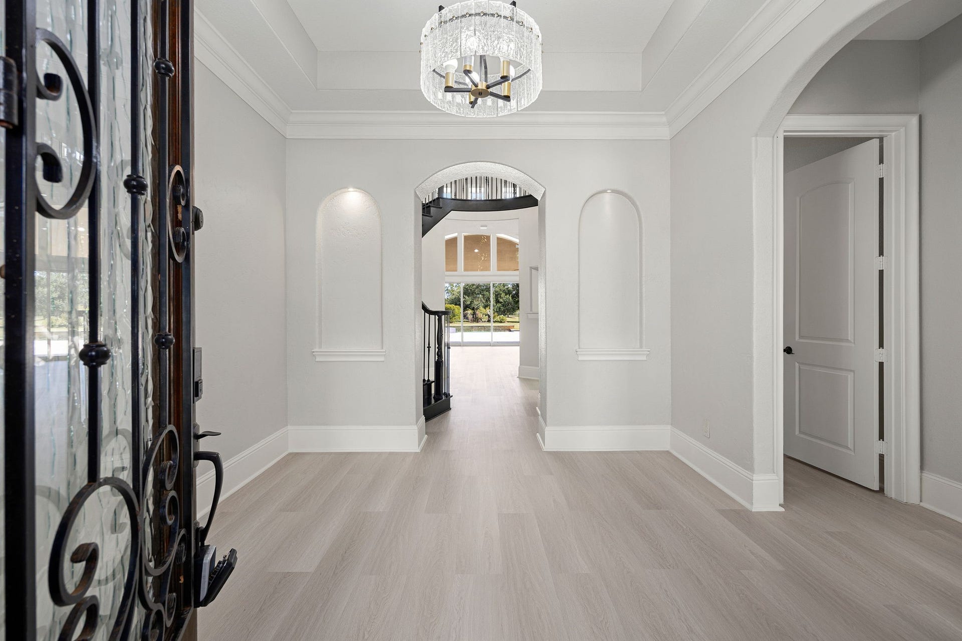 5127 Beekman Drive, Missouri City, TX 77459 A dramatic wrought-iron front door opens into a grand foyer with soaring ceilings, a statement chandelier, and new flooring that flows throughout the home.