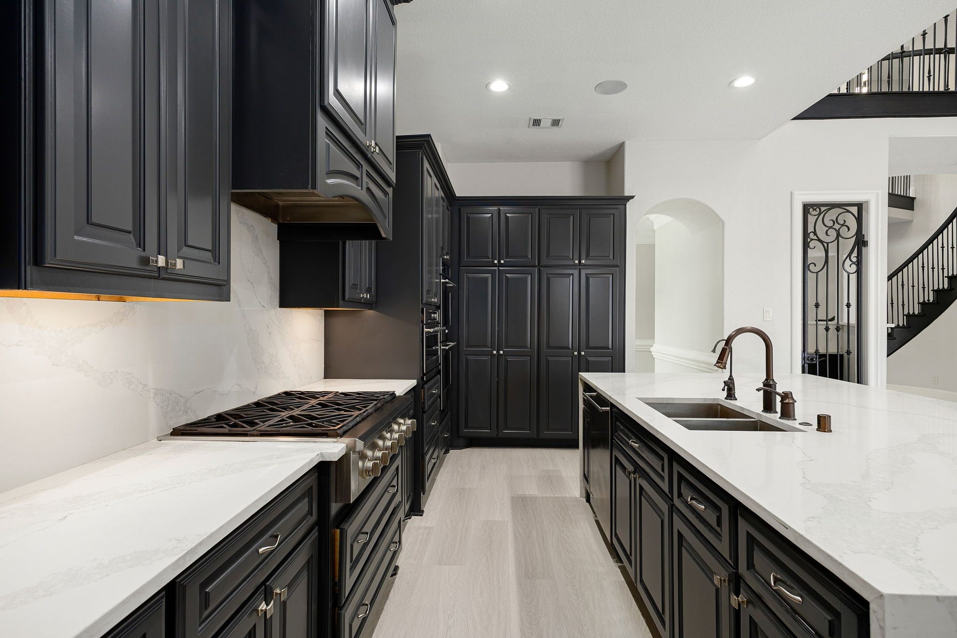 5127 Beekman Drive, Missouri City, TX 77459 A gas cooktop with a statement vent hood anchors the space, surrounded by an abundance of cabinetry and under-cabinet lighting for both style and function.