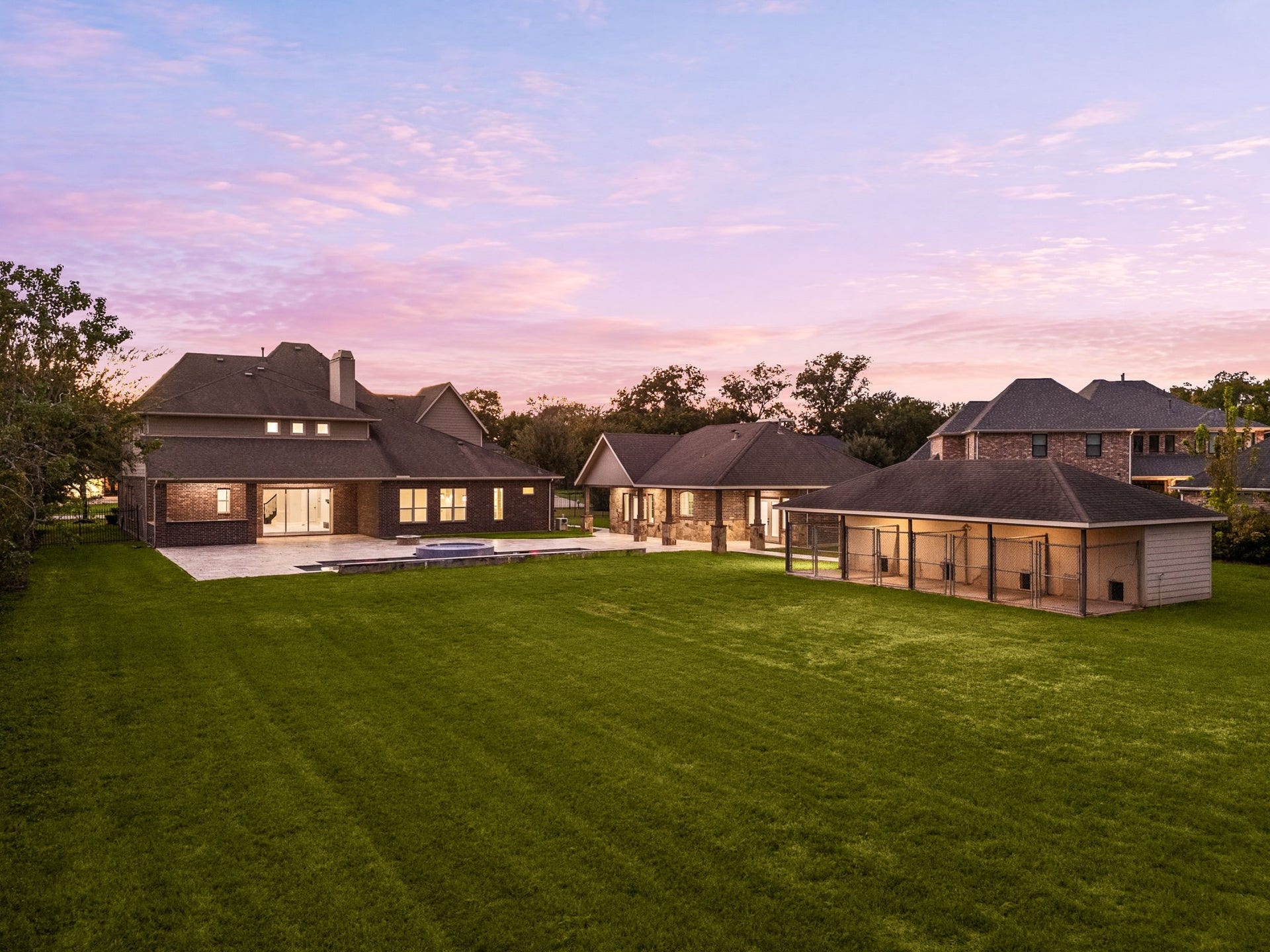 5127 Beekman Drive, Missouri City, TX 77459 This elevated view captures the full scope of the property at twilight, the main residence, casita, pool, and grounds all beautifully illuminated.