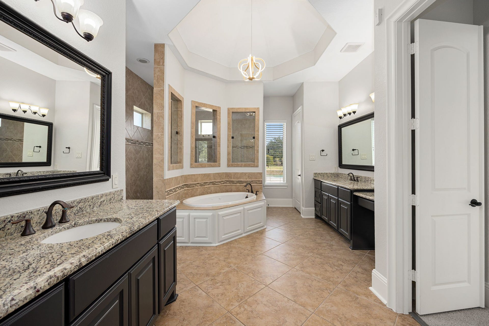 5127 Beekman Drive, Missouri City, TX 77459 A true spa retreat, the ensuite is crowned by an elegant tray ceiling and crystal chandelier, with dual vanities and a corner soaking tub framed in custom tile.