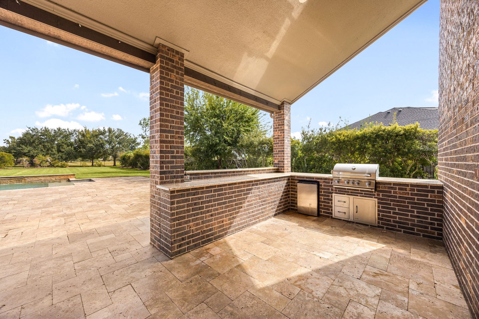 5127 Beekman Drive, Missouri City, TX 77459 A fully equipped outdoor kitchen, complete with a built-in grill, mini fridge, and granite countertops, makes al fresco entertaining effortless under the covered patio.