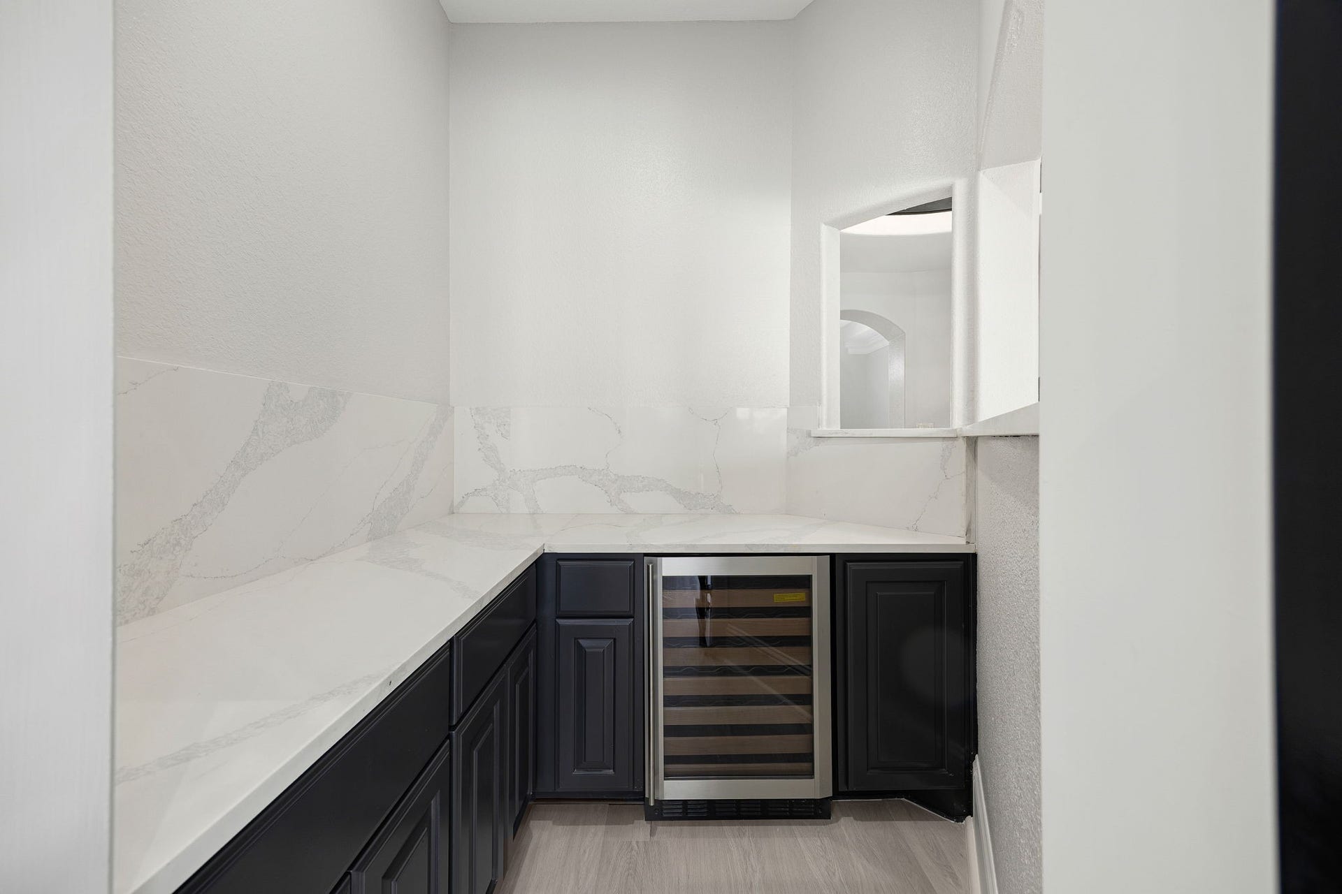 5127 Beekman Drive, Missouri City, TX 77459 A butlers pantry with a built-in wine fridge and marble-look countertops adds convenience and style, perfect for hosting.