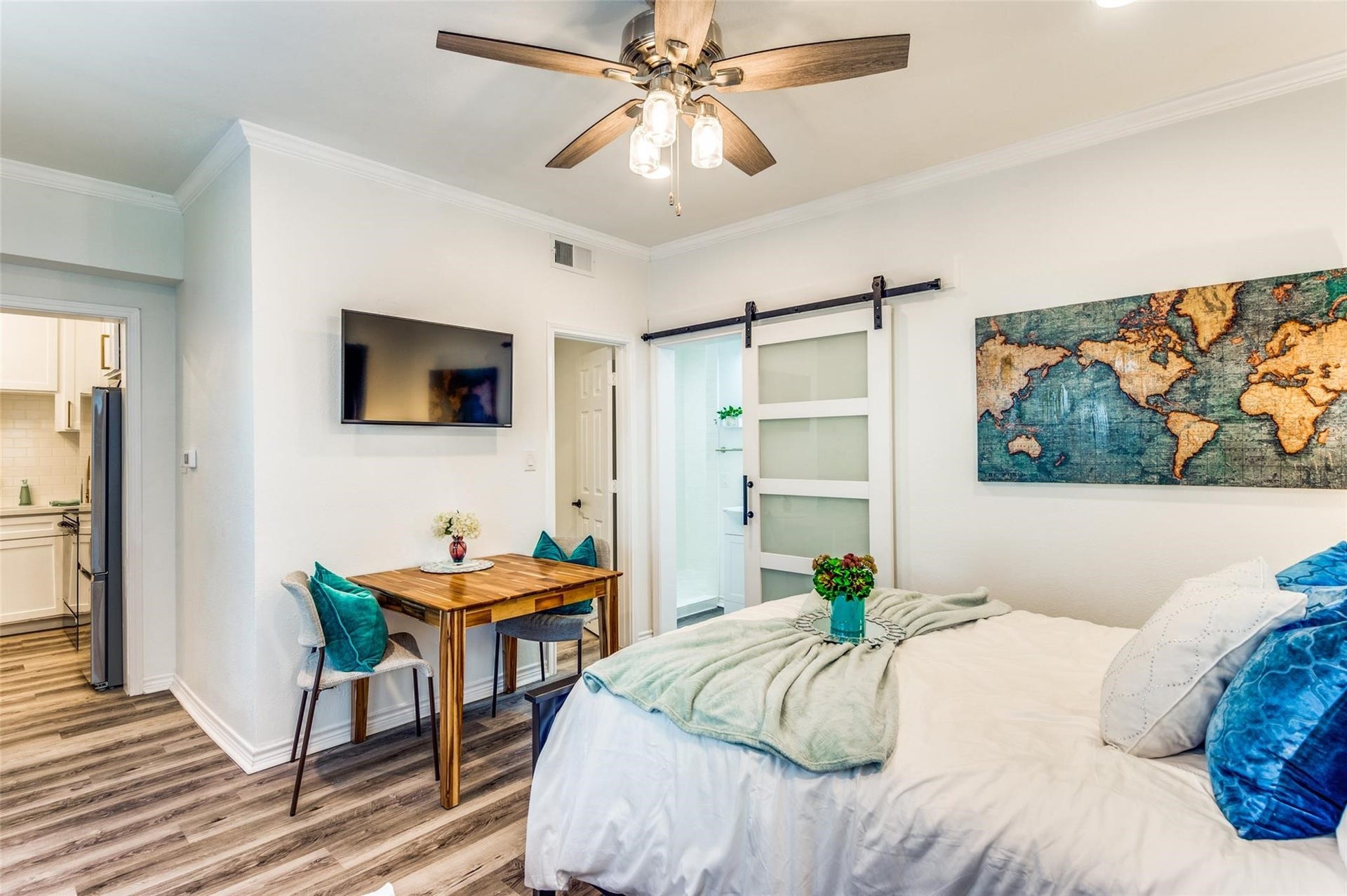 2410 Truxillo Street, #Unit C, Houston, TX 77004 Spacious Studio Living and sleeping area with modern flooring, ceiling fan, recessed lighting, large windows, and stylish barn door leading to the bathroom.