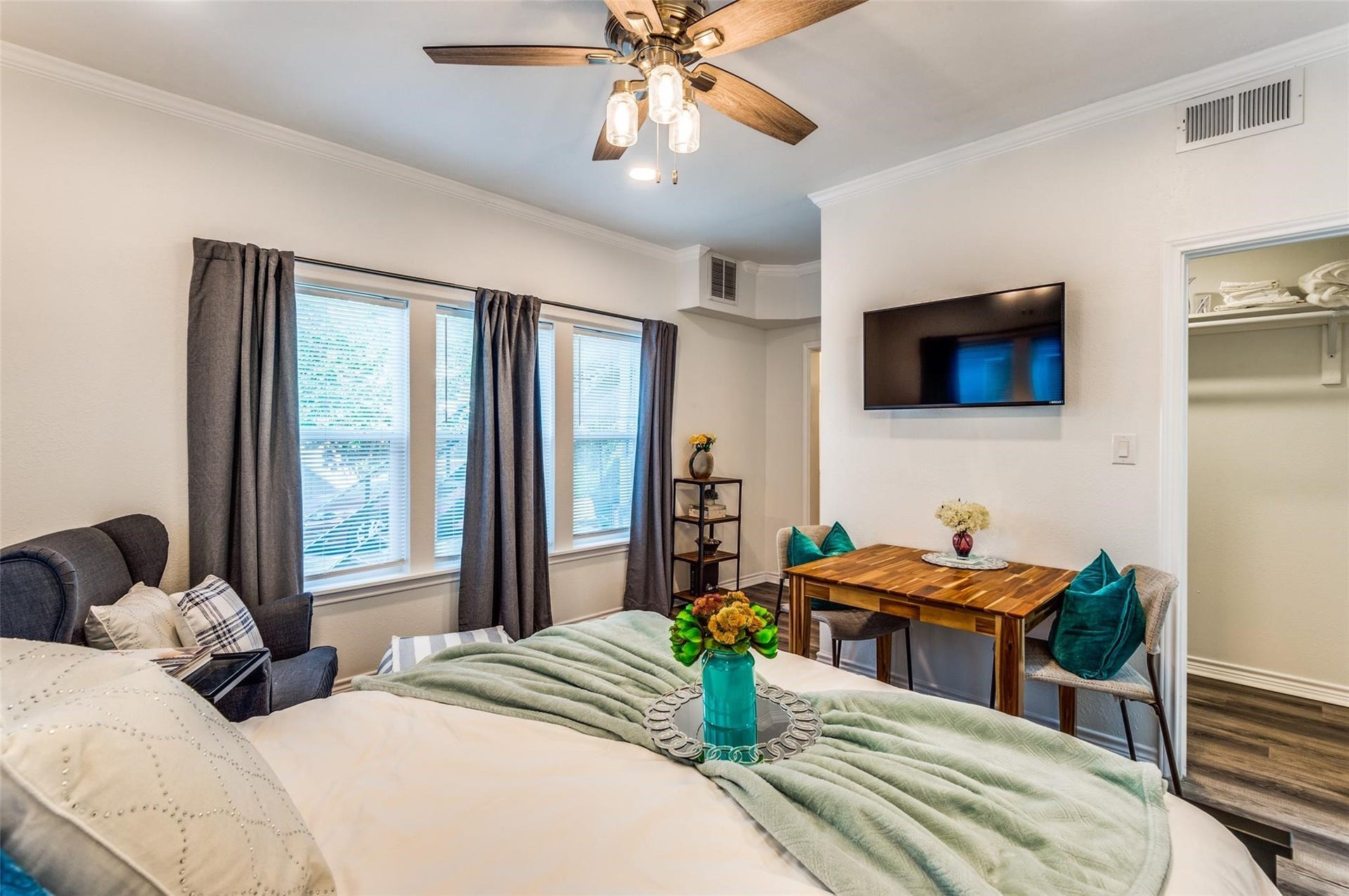 2410 Truxillo Street, #Unit C, Houston, TX 77004 Spacious Studio Living and sleeping area with modern flooring, ceiling fan, recessed lighting, large windows, and stylish barn door leading to the bathroom.