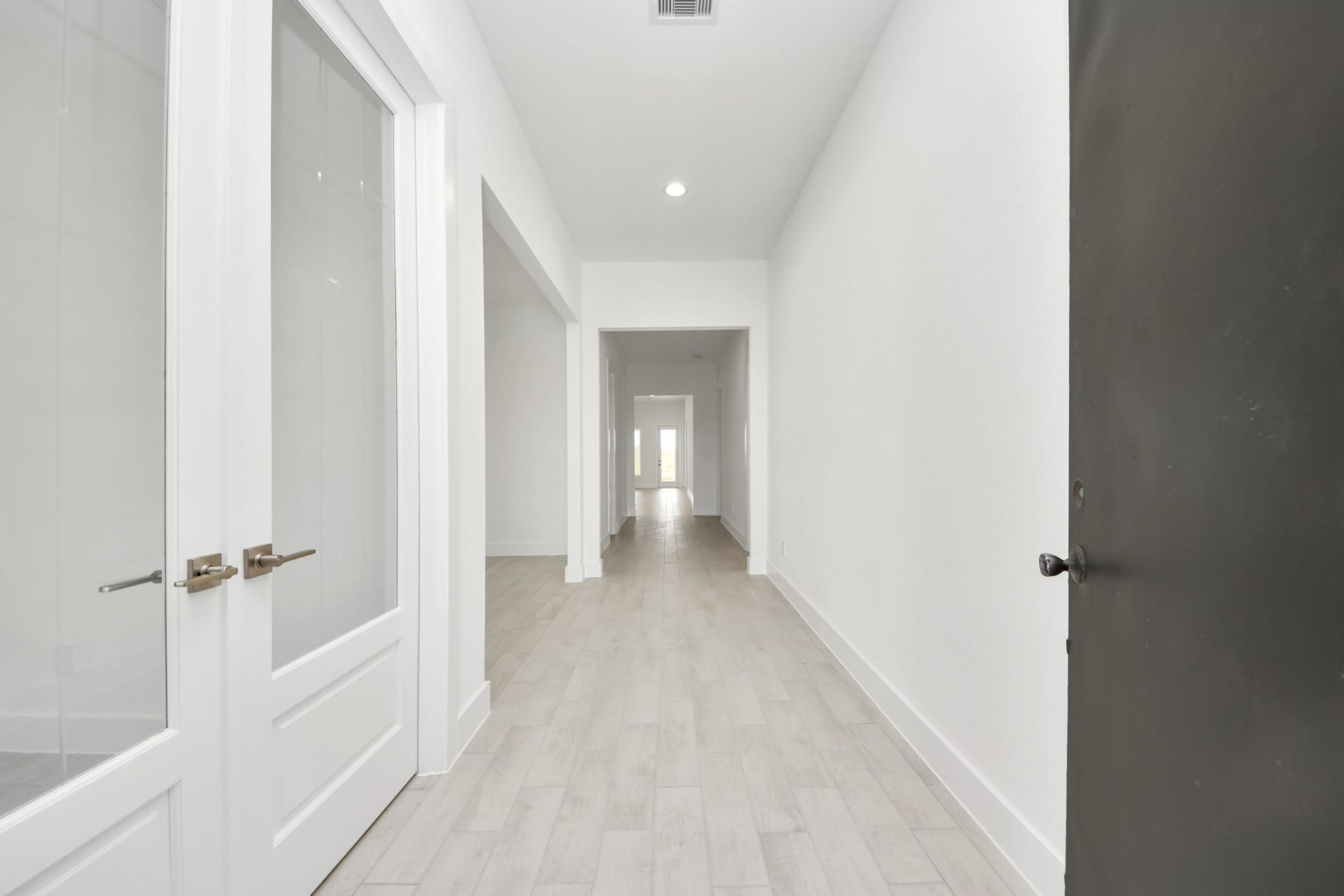 As you step into the threshold of this luxurious home, you'll soon be welcomed by an elegant glass door (to be installed). Inside, soaring ceilings amplify the spaciousness, while the refined wood-look tile flooring and oversized baseboards exude sophistication and charm. Sample photo of completed home with similar floor plan. Actual colors and selections may vary.