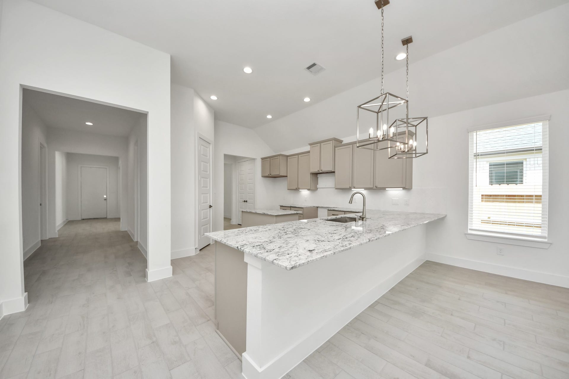 Step into a dream realized with this generously spacious kitchen! A massive granite island takes center stage, complemented by high ceilings and soft-close cabinets. The granite countertops, stainless steel appliances, sleek tile backsplash, and recessed lighting complete the elegant design. Sample photo of completed home with similar floor plan. Actual colors and selections may vary.