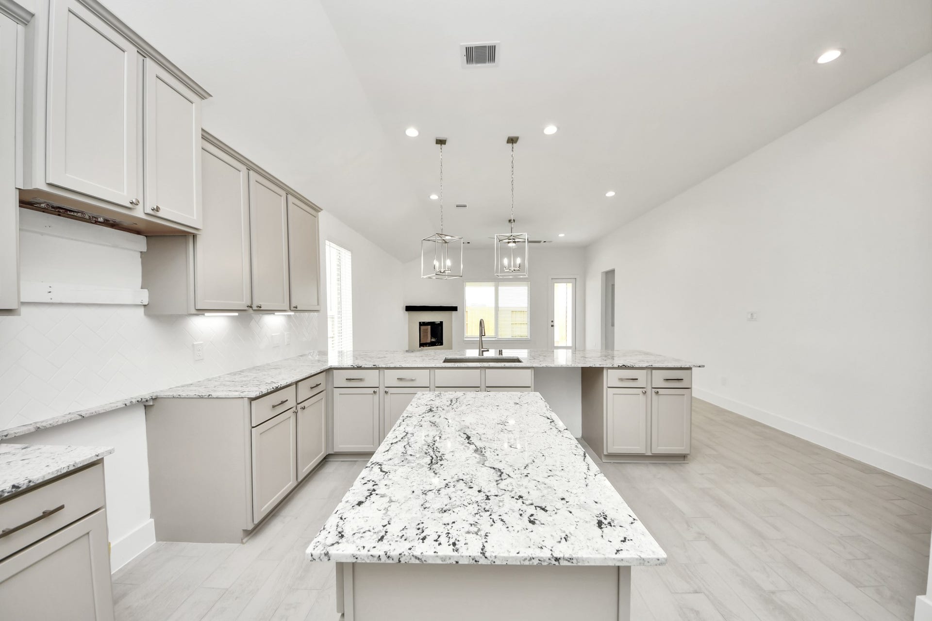 This kitchen is by far any chefs dream! This spacious kitchen features high ceilings, light stained wood cabinets, granite countertop, SS appliances, modern tile backsplash, recessed lighting, extended counter space, granite kitchen island, and space for breakfast bar, and a walk-in pantry all overlooking your huge family room. Sample photo of completed home with similar floor plan. Actual colors and selections may vary.