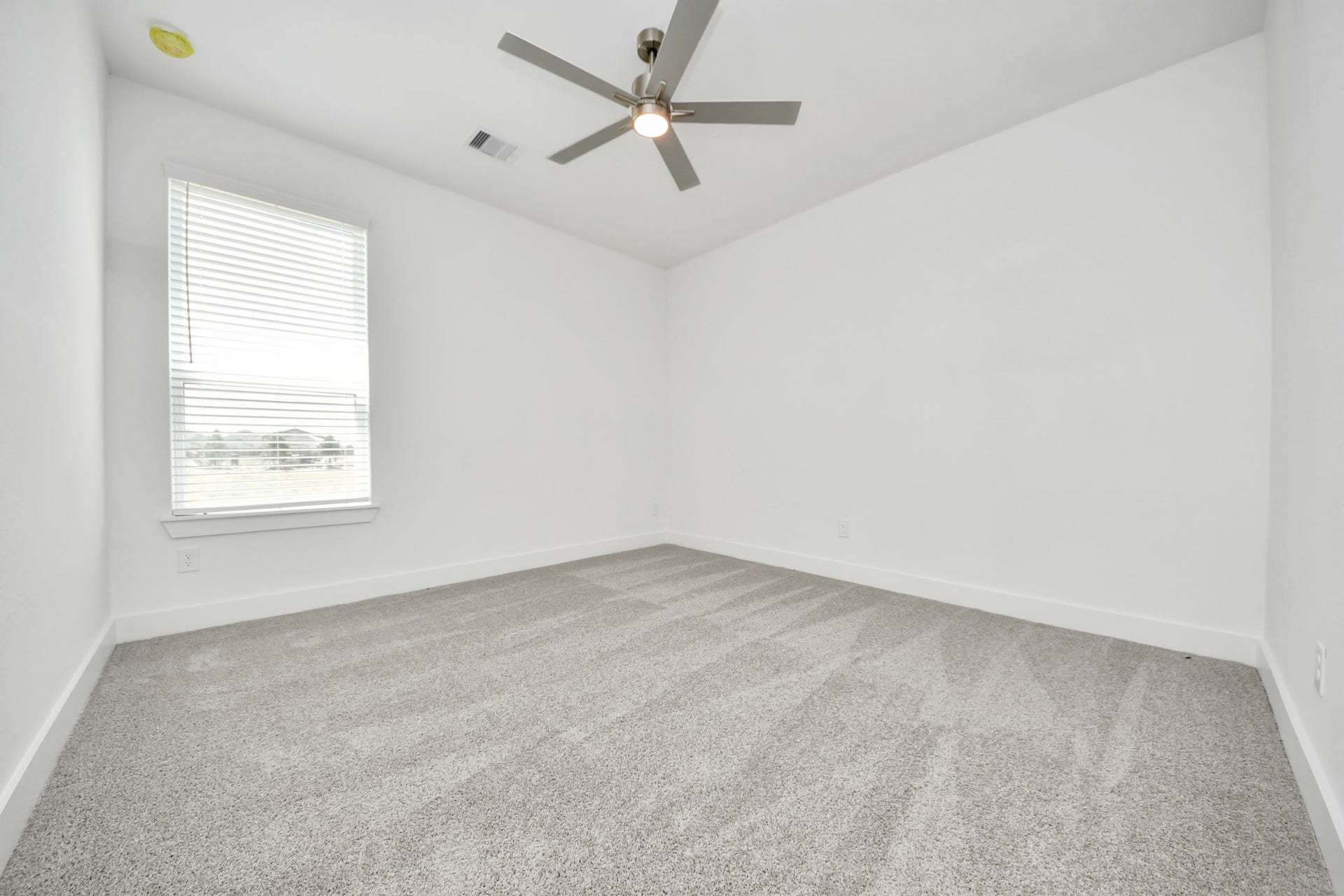 Secondary bedroom features plush carpeting, large windows that let in plenty of natural light, bright paint, and spacious closets. Sample photo of completed home with similar floor plan. Actual colors and selections may vary.