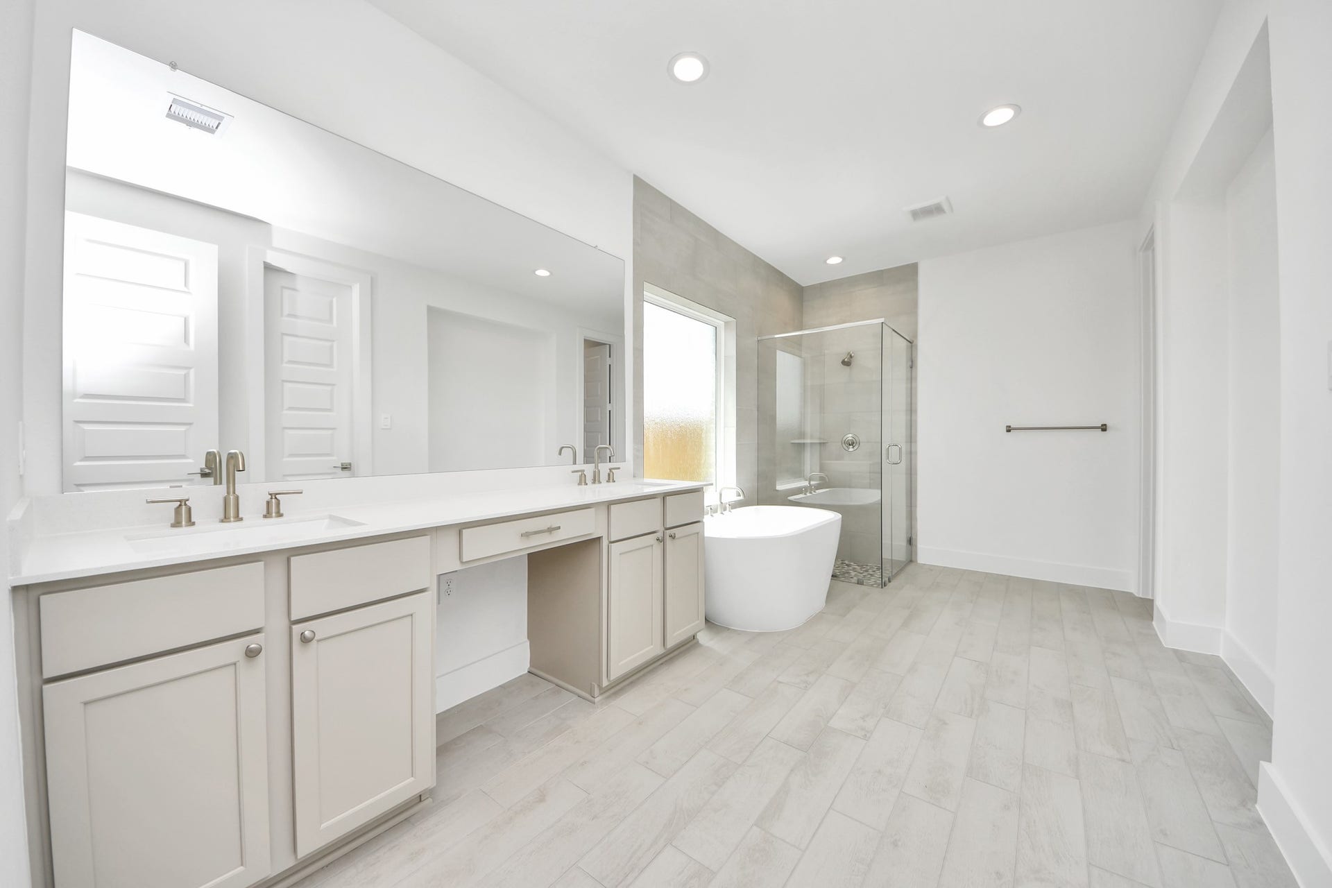 Elevate your daily routine at the elegant vanity, now equipped with double sinks, light countertops, modern hardware, and beautiful recessed lights. Sample photo of completed home with similar floor plan. Actual colors and selections may vary.