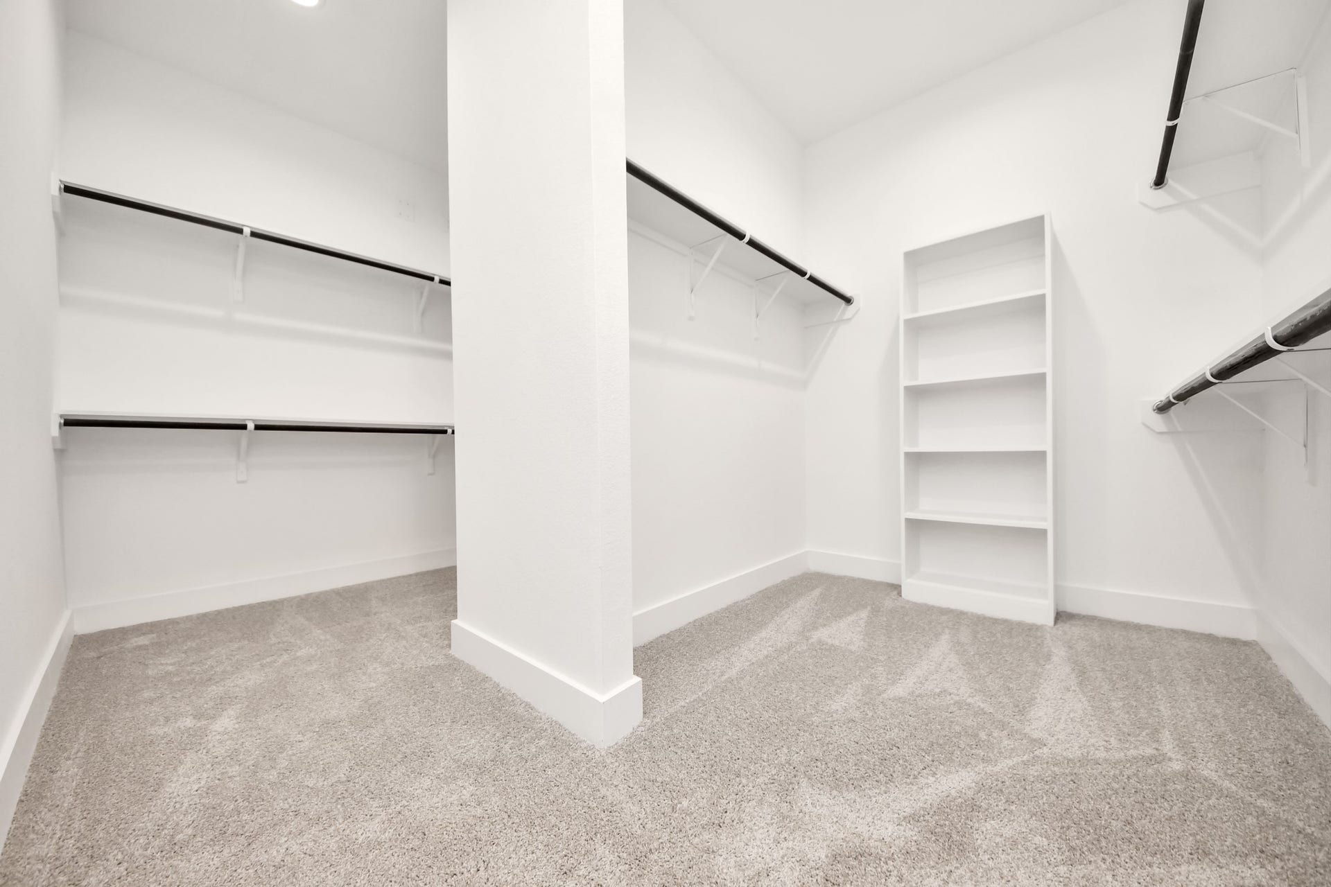 Walk-in closet that epitomizes luxury and practicality. This generously sized space features built-in shelving, offering abundant room for impeccable organization. High ceilings and recessed lighting create a bright and welcoming ambiance. Sample photo of completed home with similar floor plan. Actual colors and selections may vary.