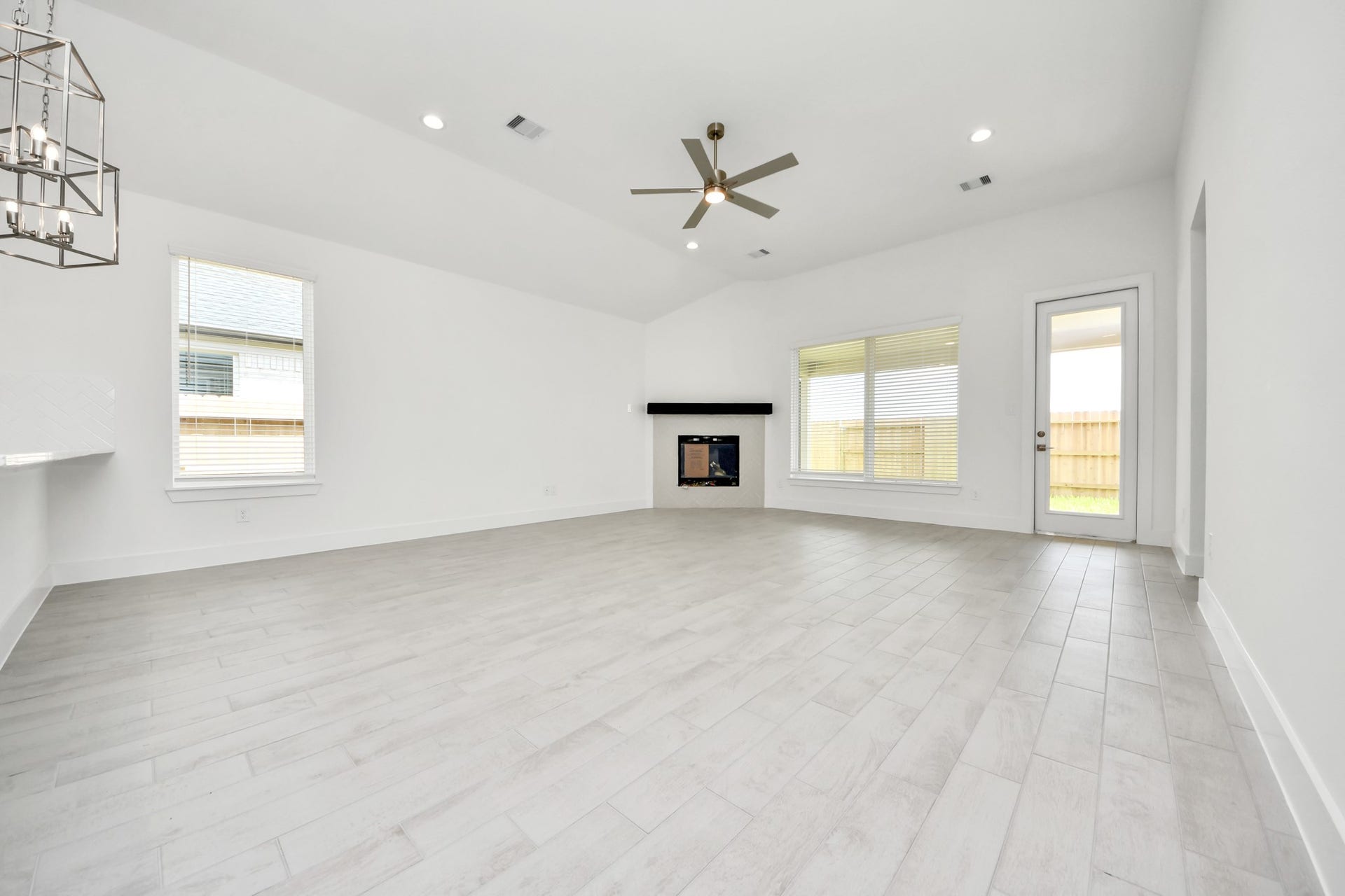 Welcome family and guests to your charming living room! With its high ceilings, recessed lighting, ceiling fan, custom paint, beautiful flooring, and large windows that let in abundant natural light, this room is perfect for gatherings. Sample photo of completed home with similar floor plan. Actual colors and selections may vary.