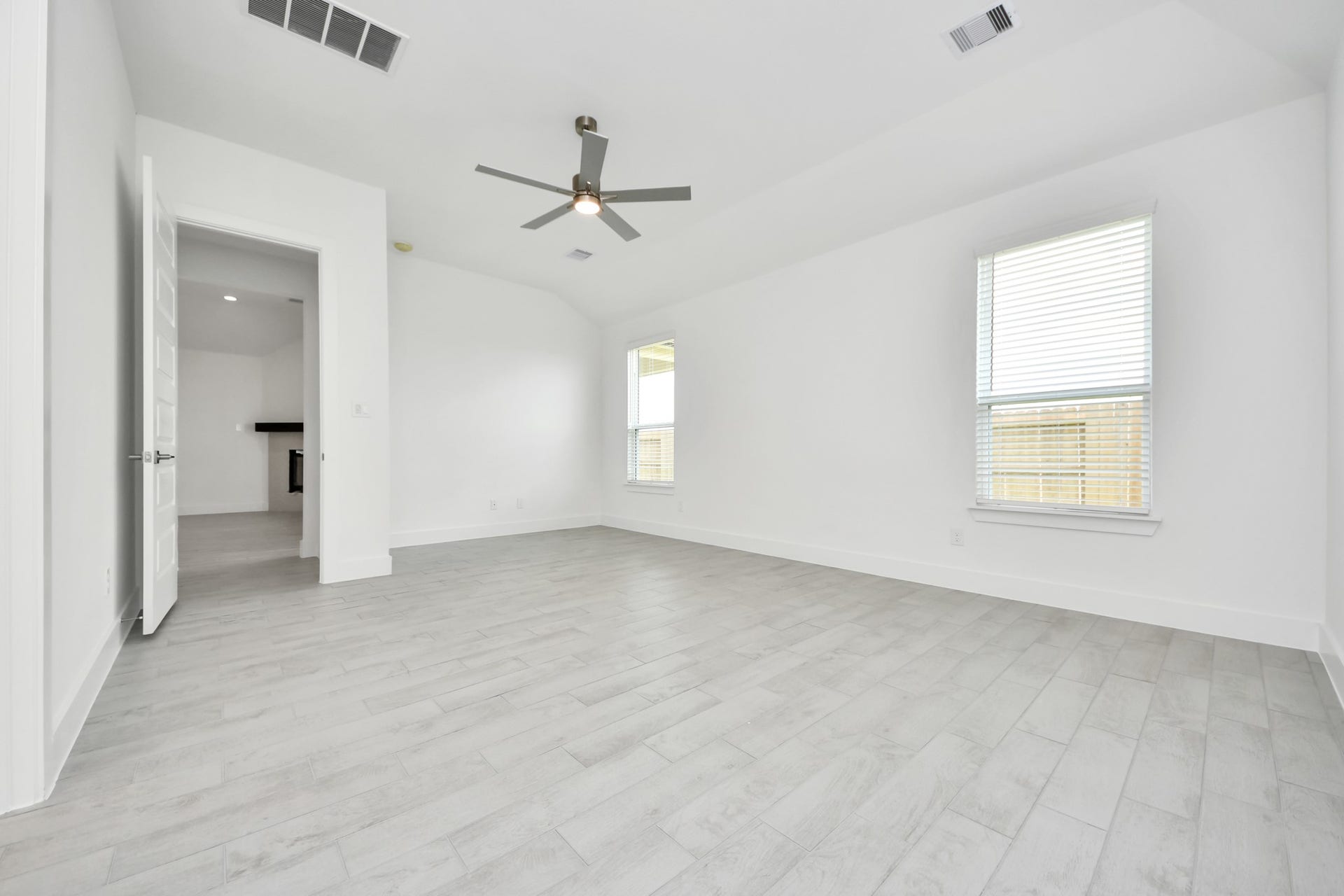 Come and unwind after a long day in this magnificent primary suite! This spacious room features warm paint, high ceilings and large windows with privacy blinds. Sample photo of completed home with similar floor plan. Actual colors and selections may vary.