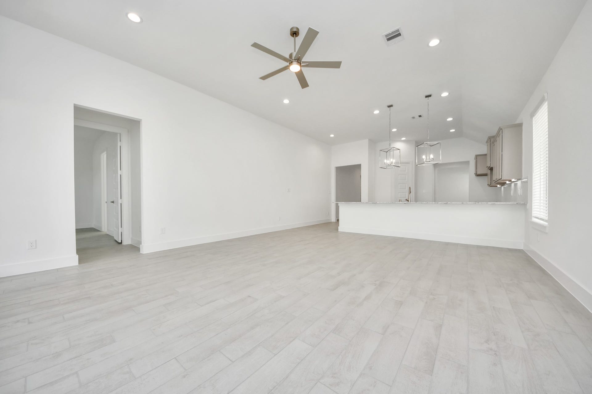 Gather the family and guests together in your lovely living room! Featuring soaring high ceilings, recessed lighting, ceiling fan, custom paint, gorgeous floors, and large windows that provide plenty of natural lighting throughout the day. Sample photo of completed home with similar floor plan. Actual colors and selections may vary.