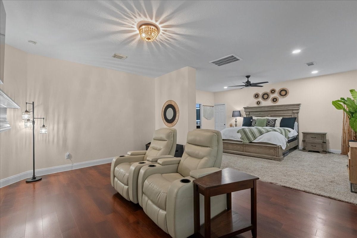 7202 Pine Drive W, Alvin, TX 77511 Spacious bedroom suite featuring a cozy seating area with plush recliners, elegant hardwood like floors, and a stylishly bed, creating a perfect retreat.