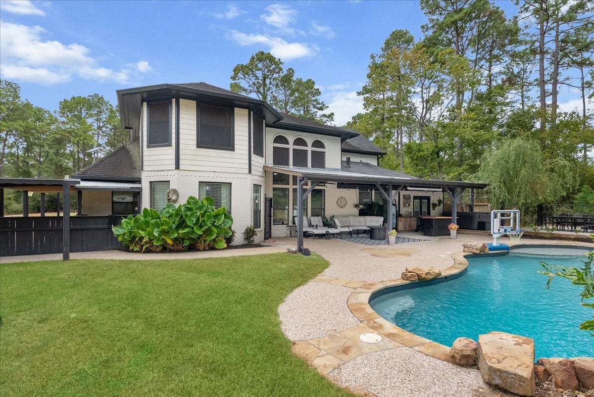 7202 Pine Drive W, Alvin, TX 77511 The back of this stunning two-story showcases a sparkling pool and lush landscaping, making it an ideal place for relaxing or entertaining.
