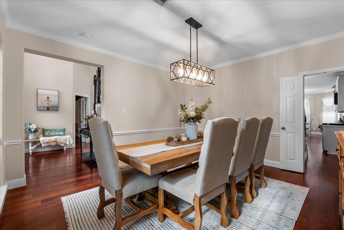 7202 Pine Drive W, Alvin, TX 77511 Elegant dining room with a stylish chandelier, rich wood like flooring, and a spacious table perfect for gatherings.