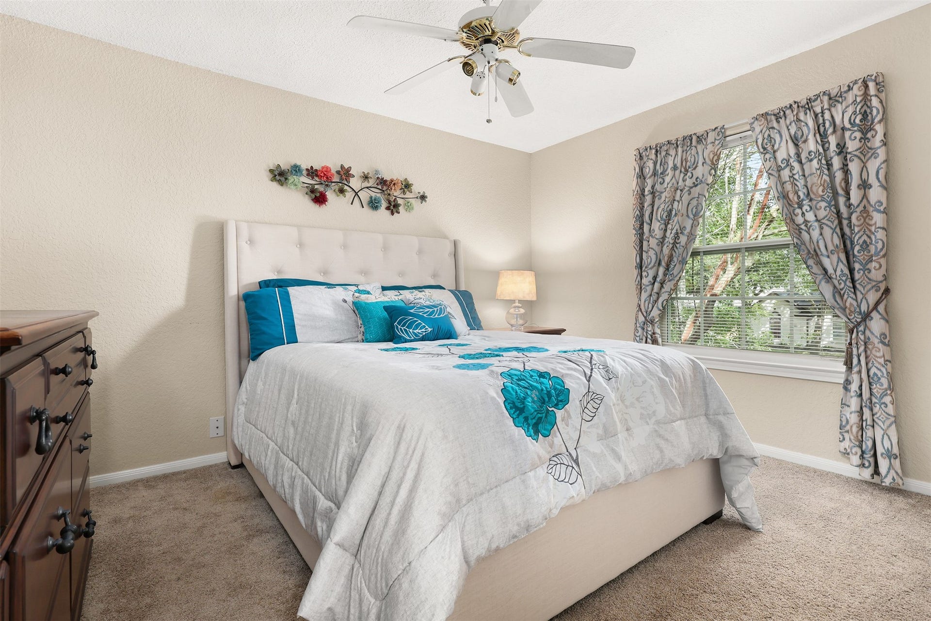 3424 Glastonbury Drive, Pearland, TX 77581 Cozy bedroom featuring a plush bed with vibrant floral accents, elegant window drapes, and a warm, inviting atmosphere.