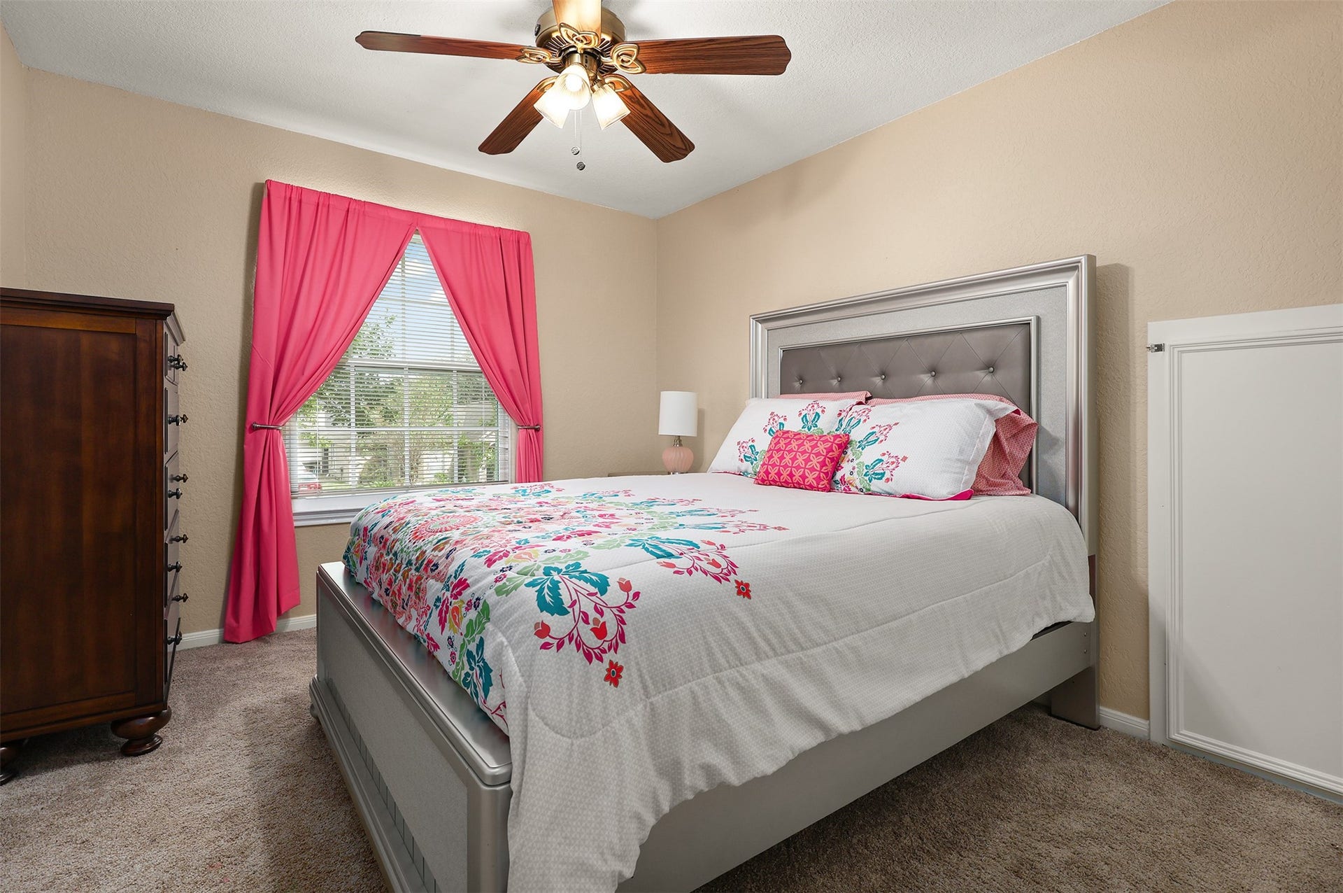 3424 Glastonbury Drive, Pearland, TX 77581 Charming bedroom with a stylish ceiling fan, and vibrant pink curtains that brighten the space overlooking the front yard.