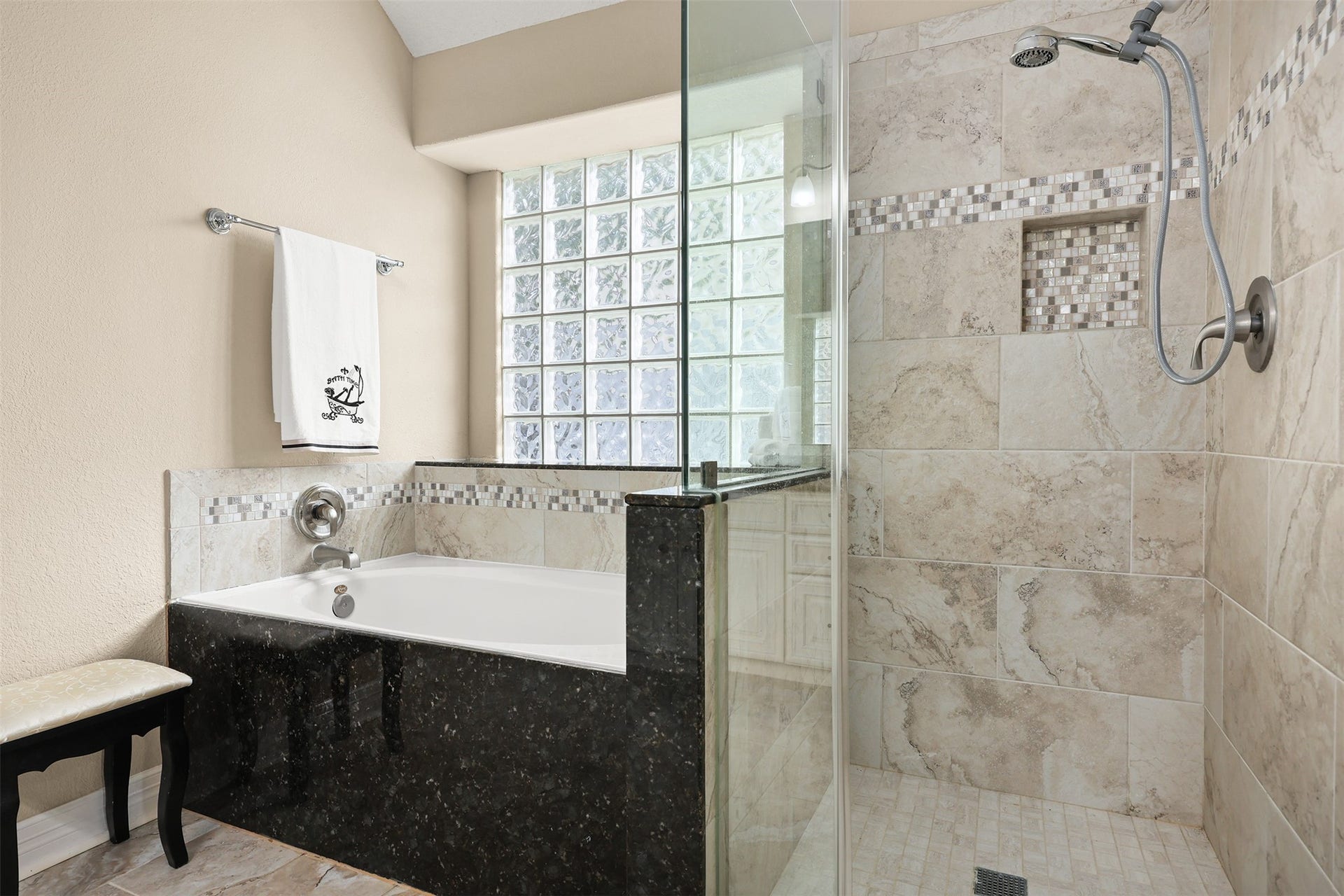 3424 Glastonbury Drive, Pearland, TX 77581 Elegant bathroom featuring a luxurious walk-in shower with glass doors and a relaxing soaking tub, beautifully accented with marble and mosaic tilework.