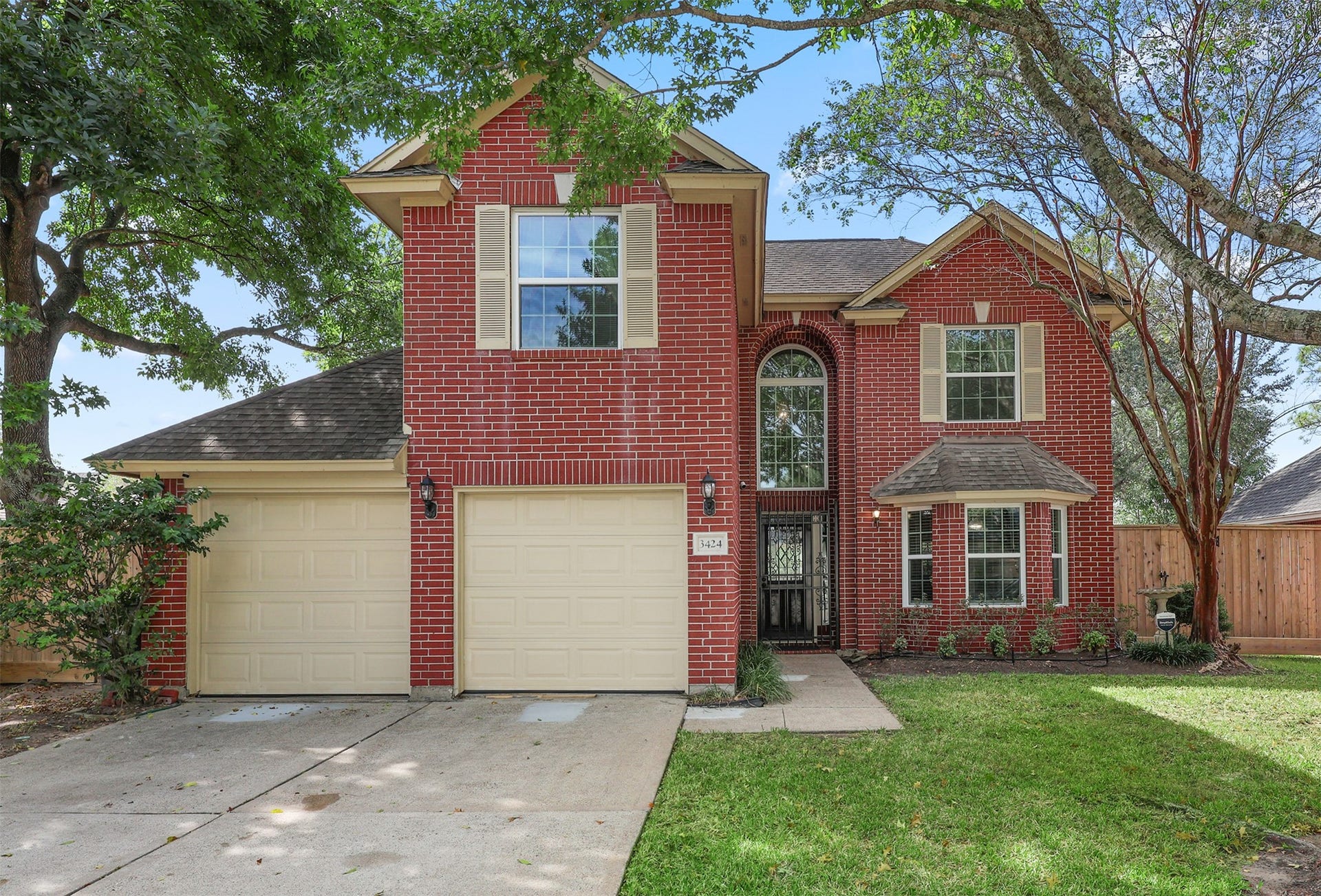 3424 Glastonbury Drive, Pearland, TX 77581 Charming two-story brick home with a welcoming facade, featuring a double garage and lush front yard shaded by mature trees.