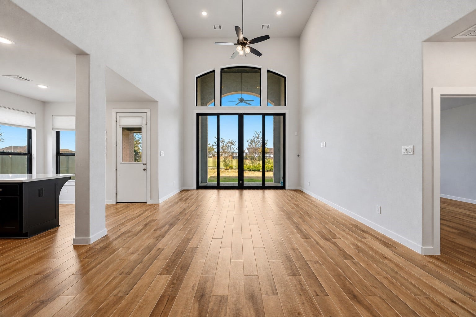 Gather the family and guests together in your huge living room! Featuring high ceilings, dark stained ceiling fan, beautiful wood-tile flooring, and 12ft tall sliding glass doors - perfect for indoor outdoor living.