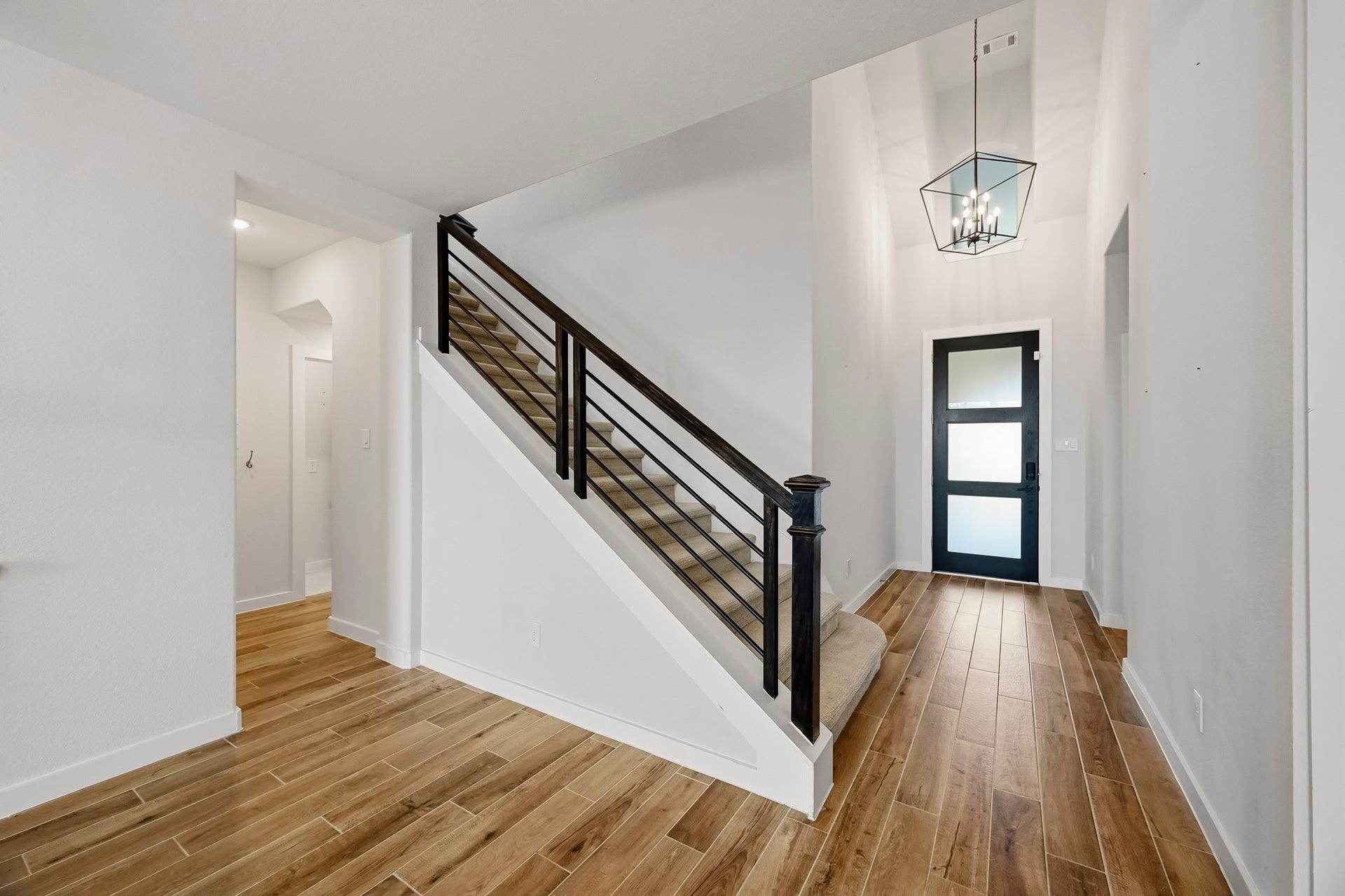 Heading back to the front of the home you see the open entry way leading to the downstairs secondary bedroom with a full bathroom and upstairs to a large game room, media room, and 2 additional bedrooms.