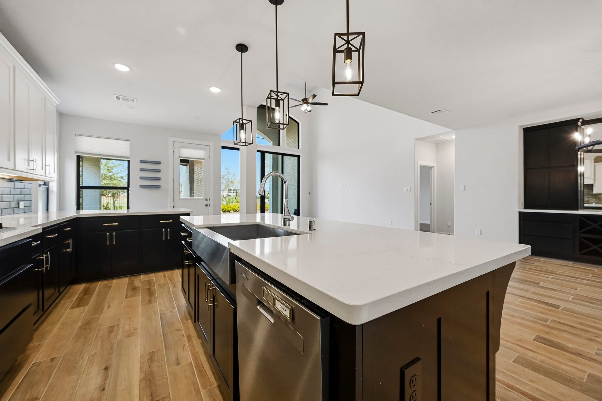 Youll love the details of this kitchen! Featuring quartz countertops, elegant tiled backsplash, a SS single basin sink, cabinet hardware, and wood tile flooring.