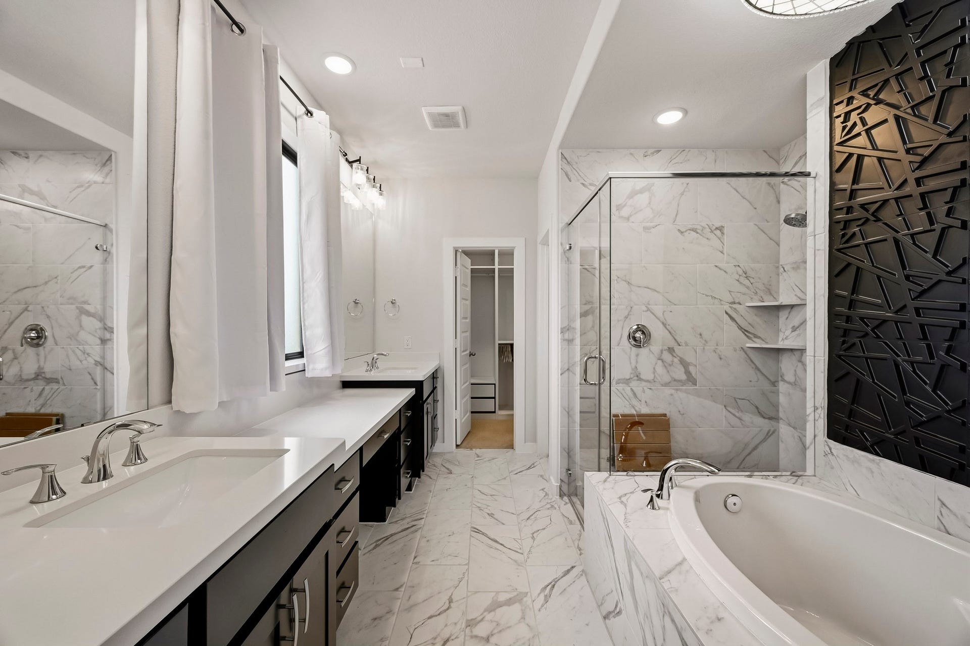Step into comfort and style in this beautiful primary bathroom! Featuring a spacious walk-in shower with mud-set tile floors & glass surround, beautiful tilework, a serene garden tub, and a custom accent wall!