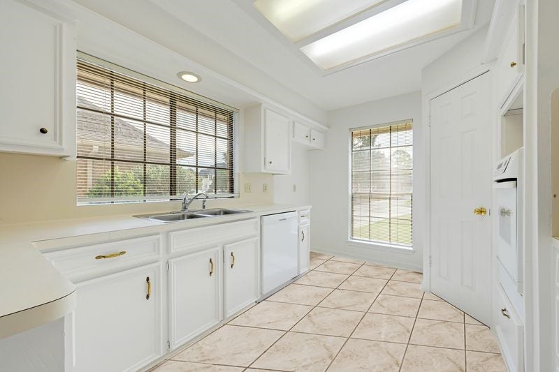 9907 Sagegreen Drive, Houston, TX 77089 Bright, airy kitchen with sleek white cabinetry, modern appliances, and large windows for ample natural light.