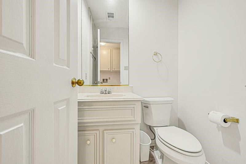 9907 Sagegreen Drive, Houston, TX 77089 Bright and clean half bathroom featuring a classic white vanity, modern fixtures, and ample storage.