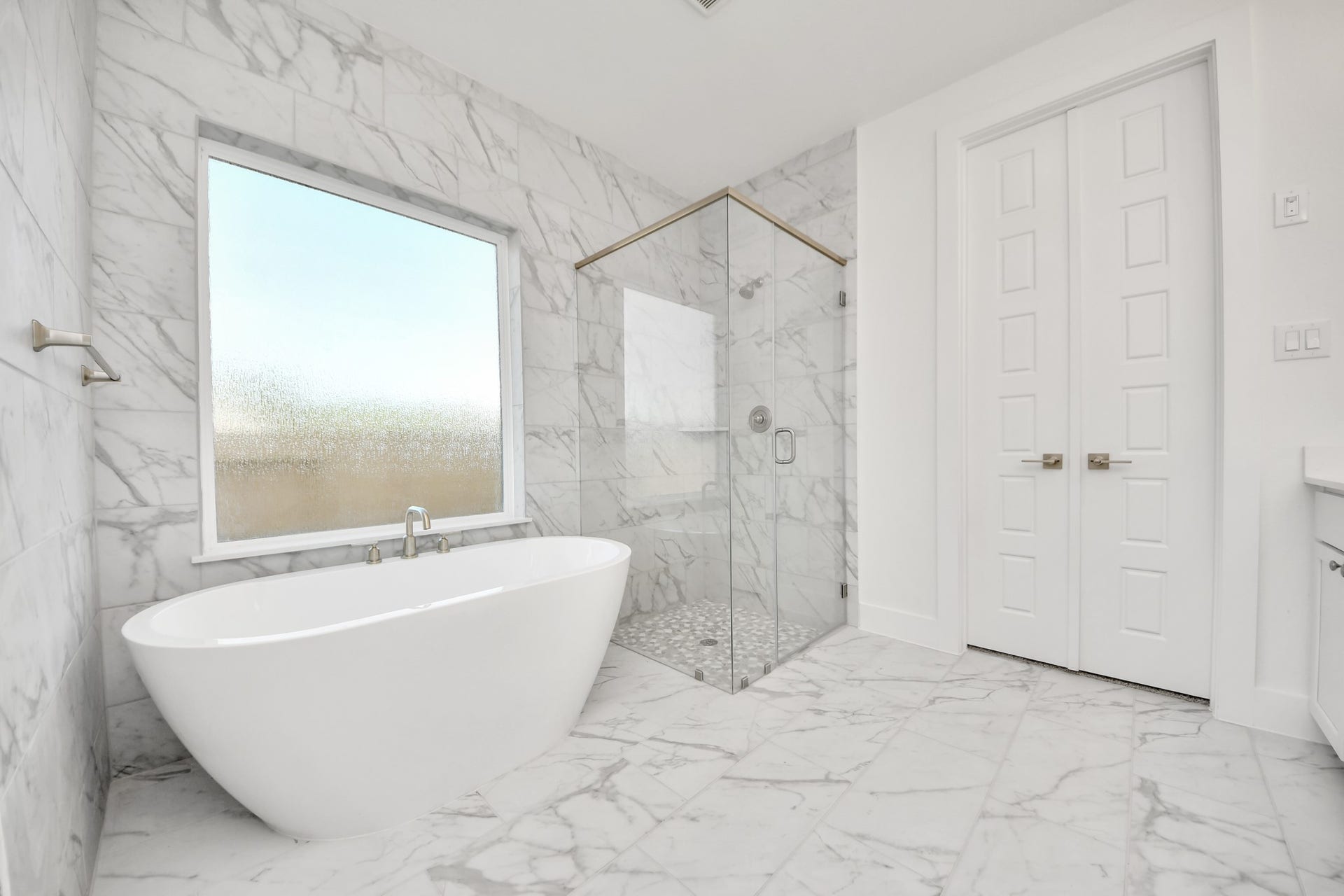 2056 Thimbleberry Lane, Magnolia, TX 77355 Indulge in a spa-like retreat within the confines of this primary bathroom. Delight in a spacious walk-in shower enveloped in stylish tile surround, unwind in a separate garden tub adorned with custom detailing.
