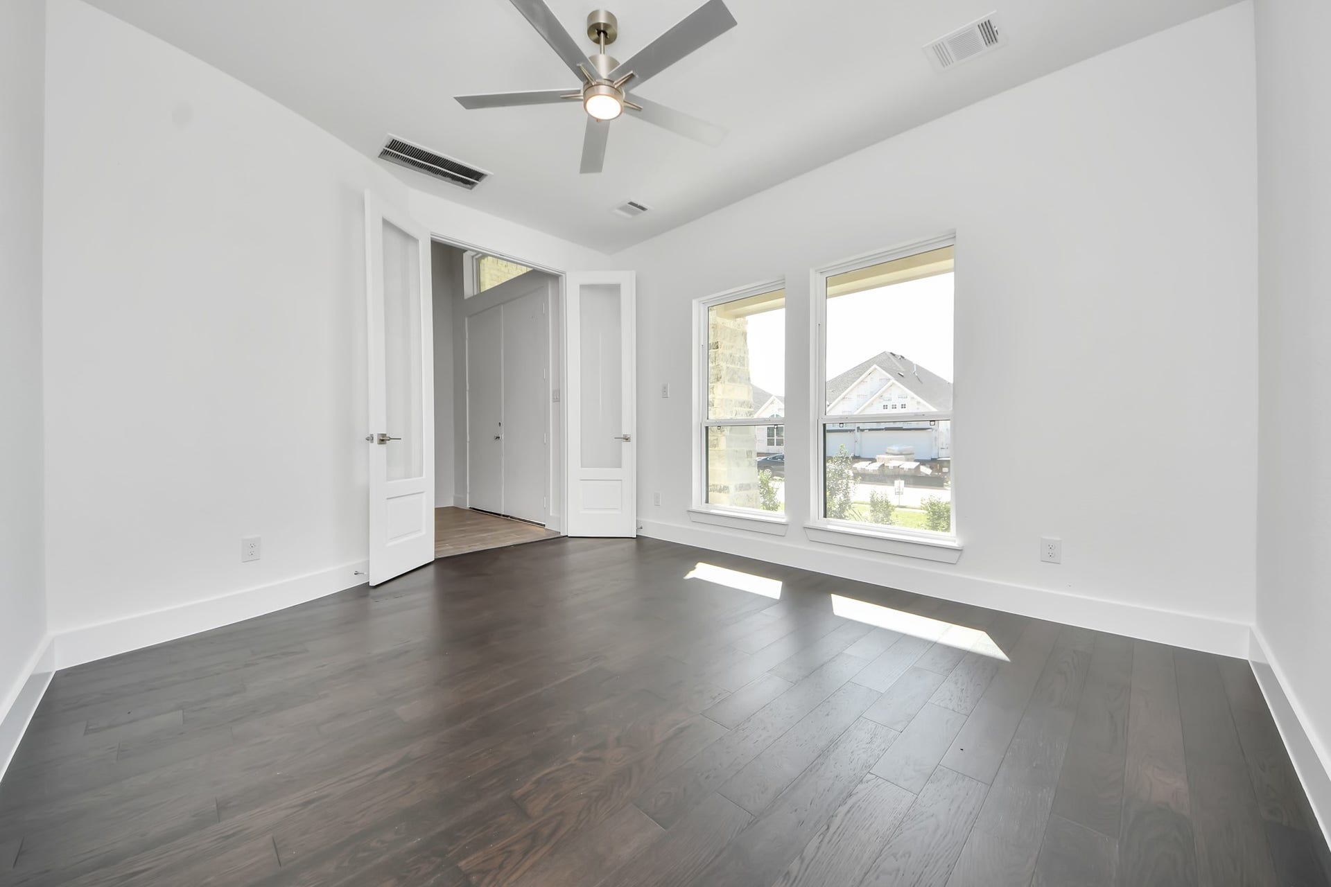 2056 Thimbleberry Lane, Magnolia, TX 77355 Experience the perfect blend of sophistication and warmth in this home office, boasting elegant wood-look tile flooring and flooded with natural light from expansive windows and French doors.