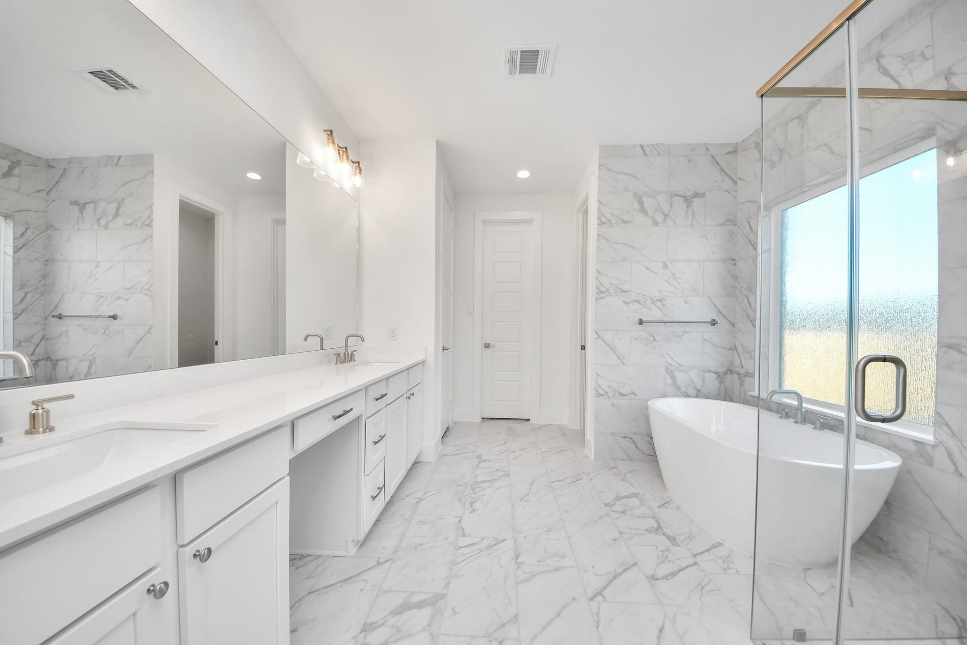 2056 Thimbleberry Lane, Magnolia, TX 77355 Escape to a spa-like oasis in this primary bathroom. Enjoy a walk-in shower with tile surround, a separate garden tub with custom detailing, and an elegant vanity featuring light countertops, modern hardware, and beautiful vanity lights. Experience luxury and relaxation in every detail.