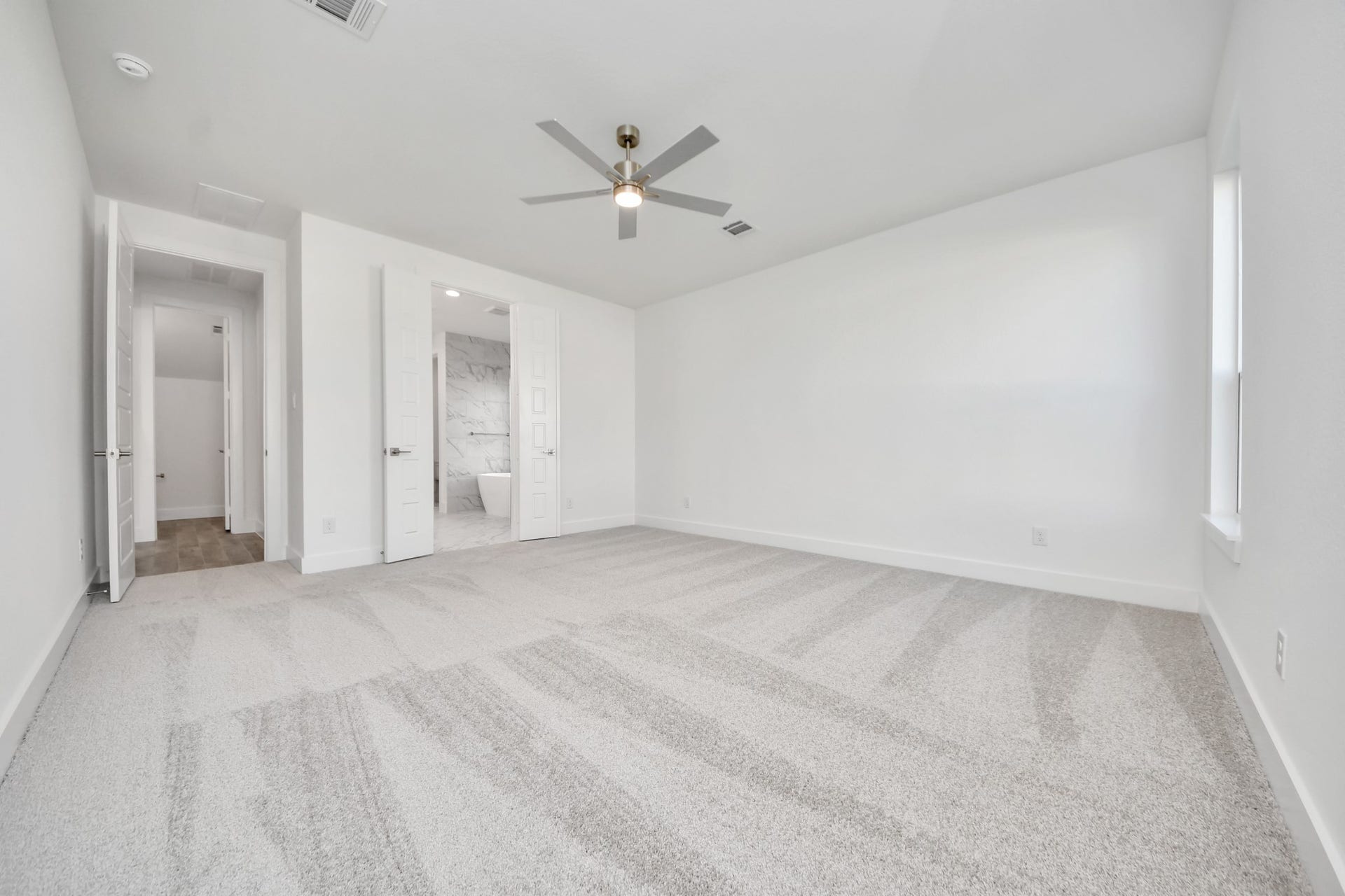 2056 Thimbleberry Lane, Magnolia, TX 77355 Escape and relax in the exquisite primary suite, a haven to unwind after a long day. The spacious room, located on first floor, boasts plush carpeting, soothing paint tones, high ceilings, and expansive windows adorned with privacy blinds.
