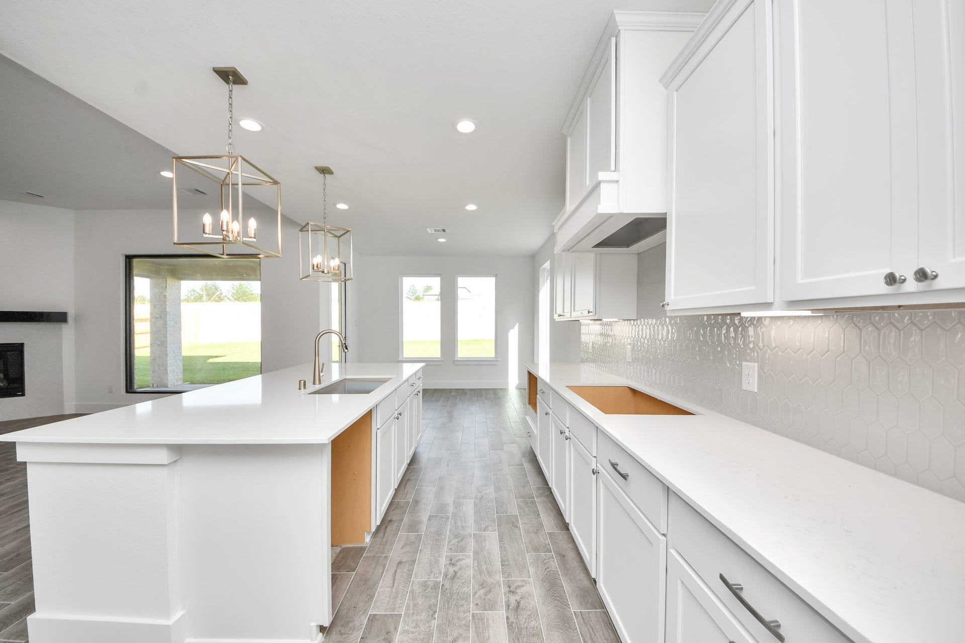 2056 Thimbleberry Lane, Magnolia, TX 77355 This kitchen is truly a chef's dream! This haven Boasts high ceilings, recessed & pendant lighting, stained wood cabinets, granite countertops, stainless steel appliances, a modern tile backsplash. All of this overlooks your expansive family room, creating a perfect space for culinary delights and family gatherings.