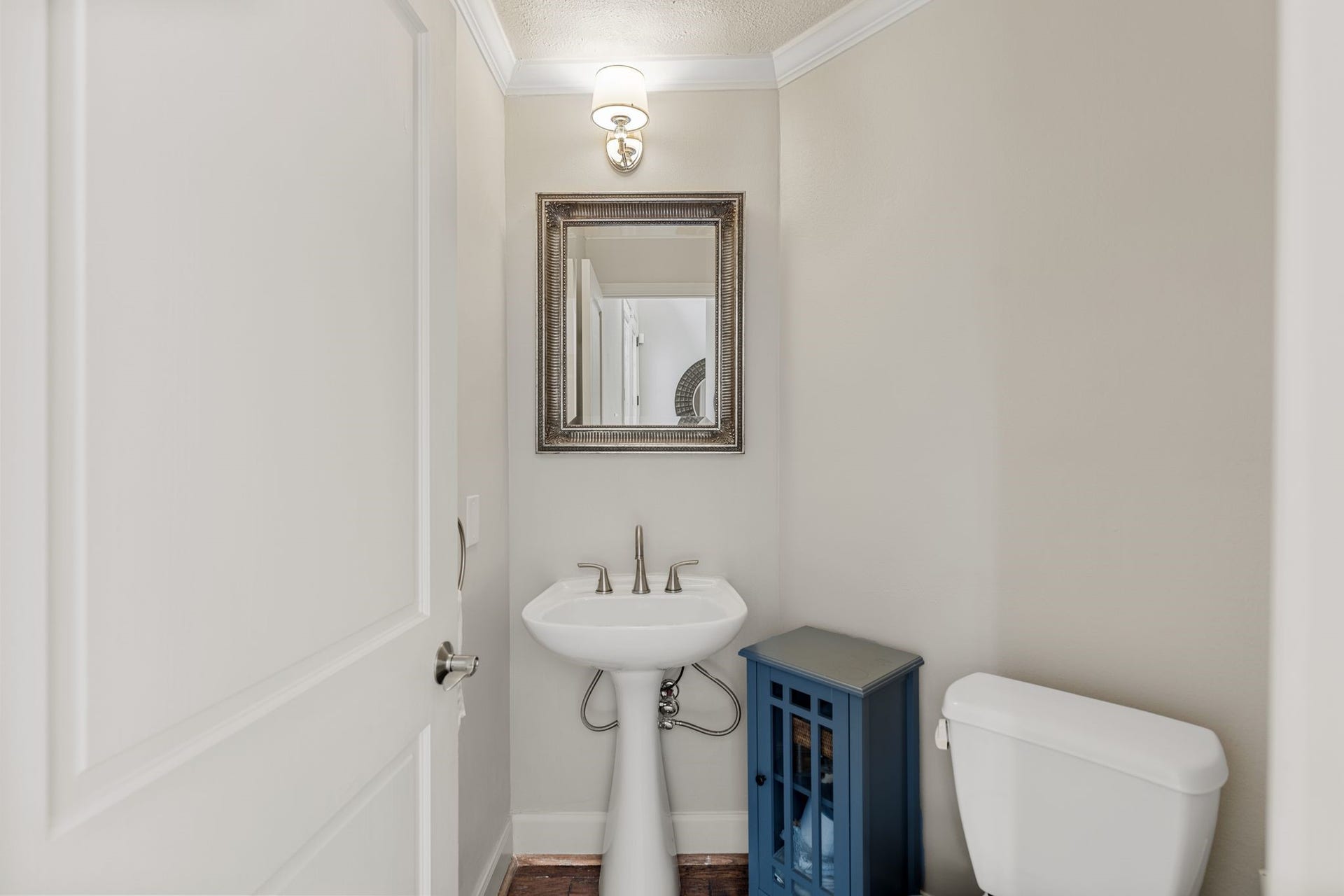 1918 Stoney Brook Drive, Houston, TX 77063 The powder room features a classic pedestal sink, decorative framed mirror and wall sconce lighting. It is discreetly located next to the mud room off entry.
