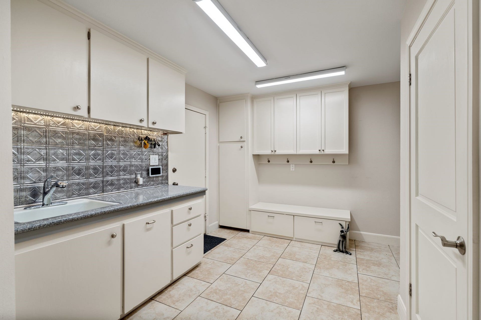 1918 Stoney Brook Drive, Houston, TX 77063 A spacious mud room offers a sink, extensive cabinetry and a built-in storage bench to help keep everyday essentials organized.