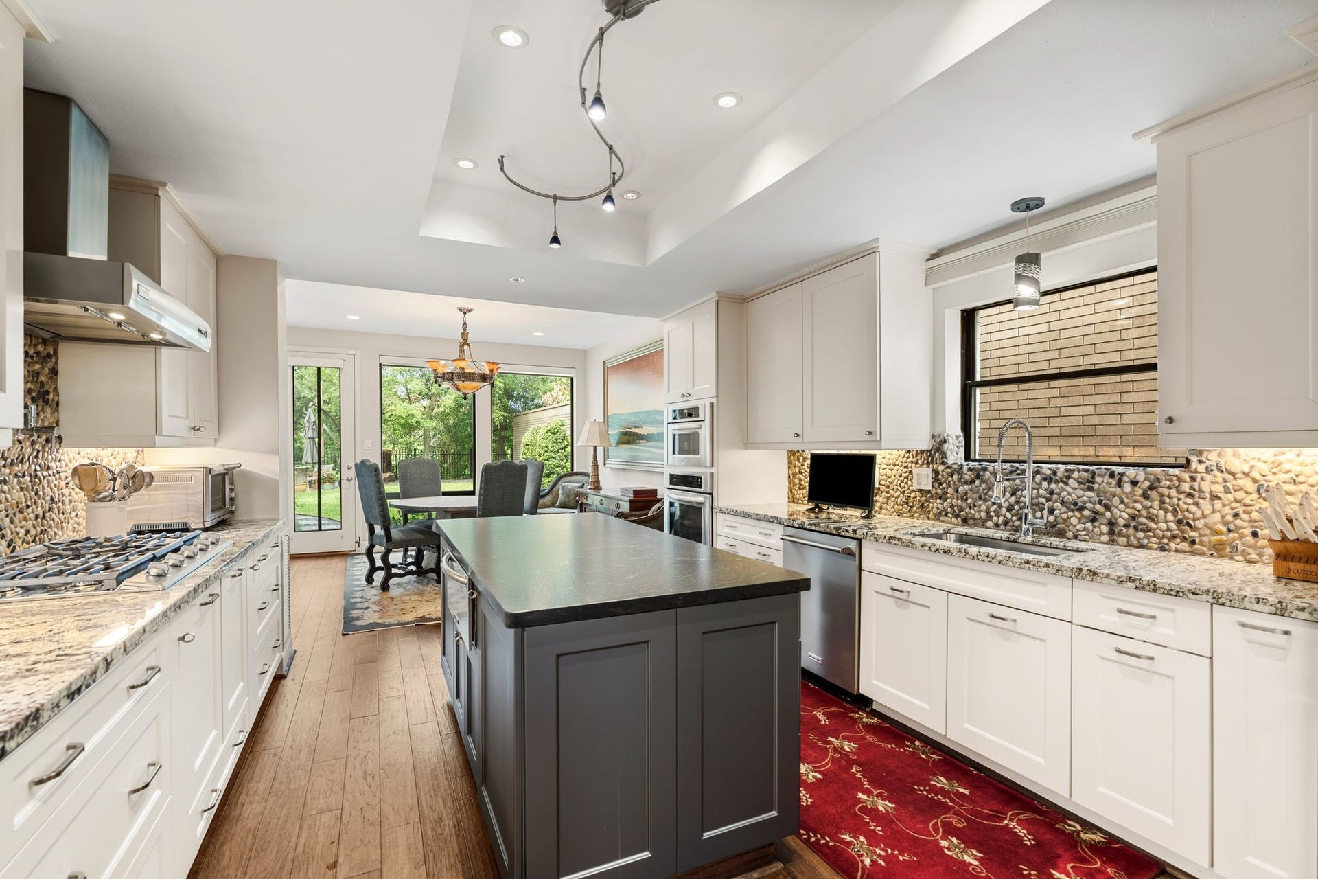 1918 Stoney Brook Drive, Houston, TX 77063 Generous work surfaces, a central island and extensive drawer storage provide a practical kitchen layout, complemented by stainless appliances and undercabinet lighting.