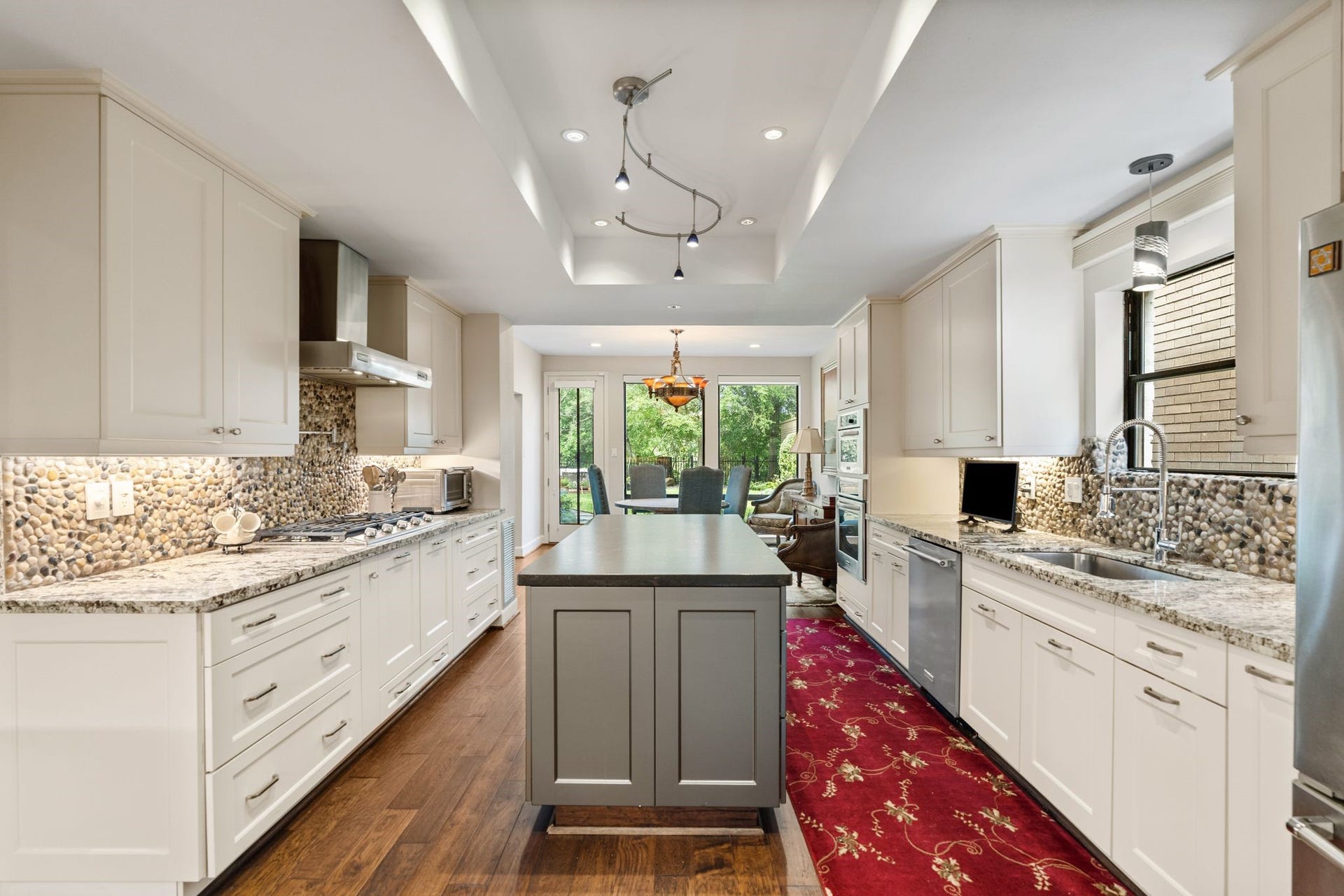 1918 Stoney Brook Drive, Houston, TX 77063 The spacious island kitchen combines abundant cabinetry, granite countertops and gas cooking, with a bright breakfast area overlooking the greenery beyond.