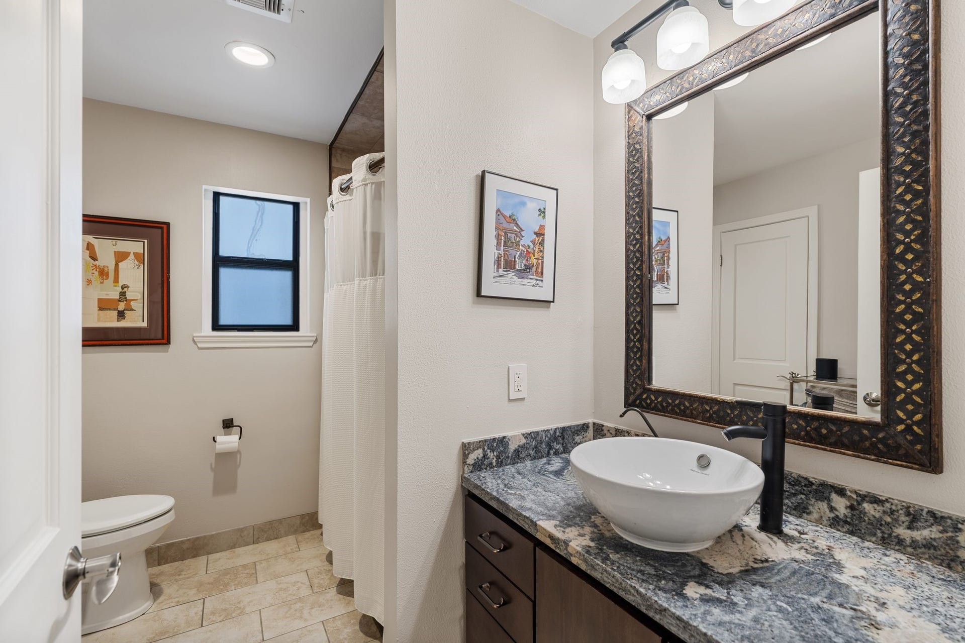 1918 Stoney Brook Drive, Houston, TX 77063 A vessel sink, striking stone countertop and decorative framed mirror give the secondary bathroom a distinctive look.