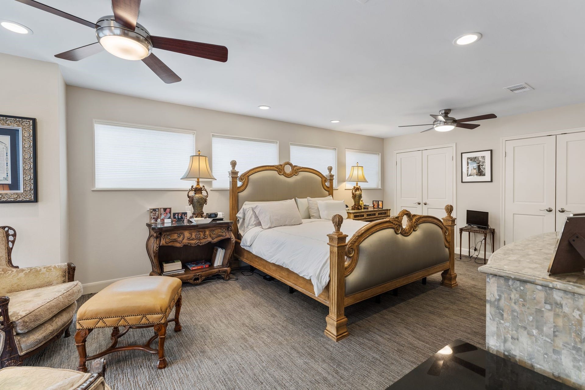 1918 Stoney Brook Drive, Houston, TX 77063 The spacious primary bedroom accommodates a substantial bedroom suite, complemented by multiple windows, recessed lighting and two ceiling fans. Additional closet space is shown behind the two sets of doors.