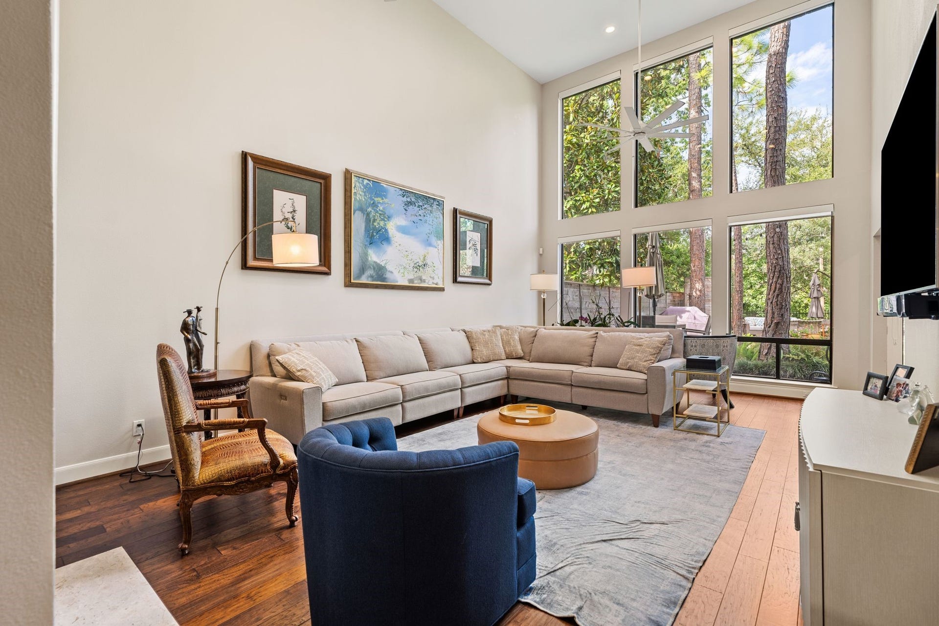 1918 Stoney Brook Drive, Houston, TX 77063 Dramatic two-story windows fill the living room with natural light and frame views of mature trees and the landscaped outdoor setting.