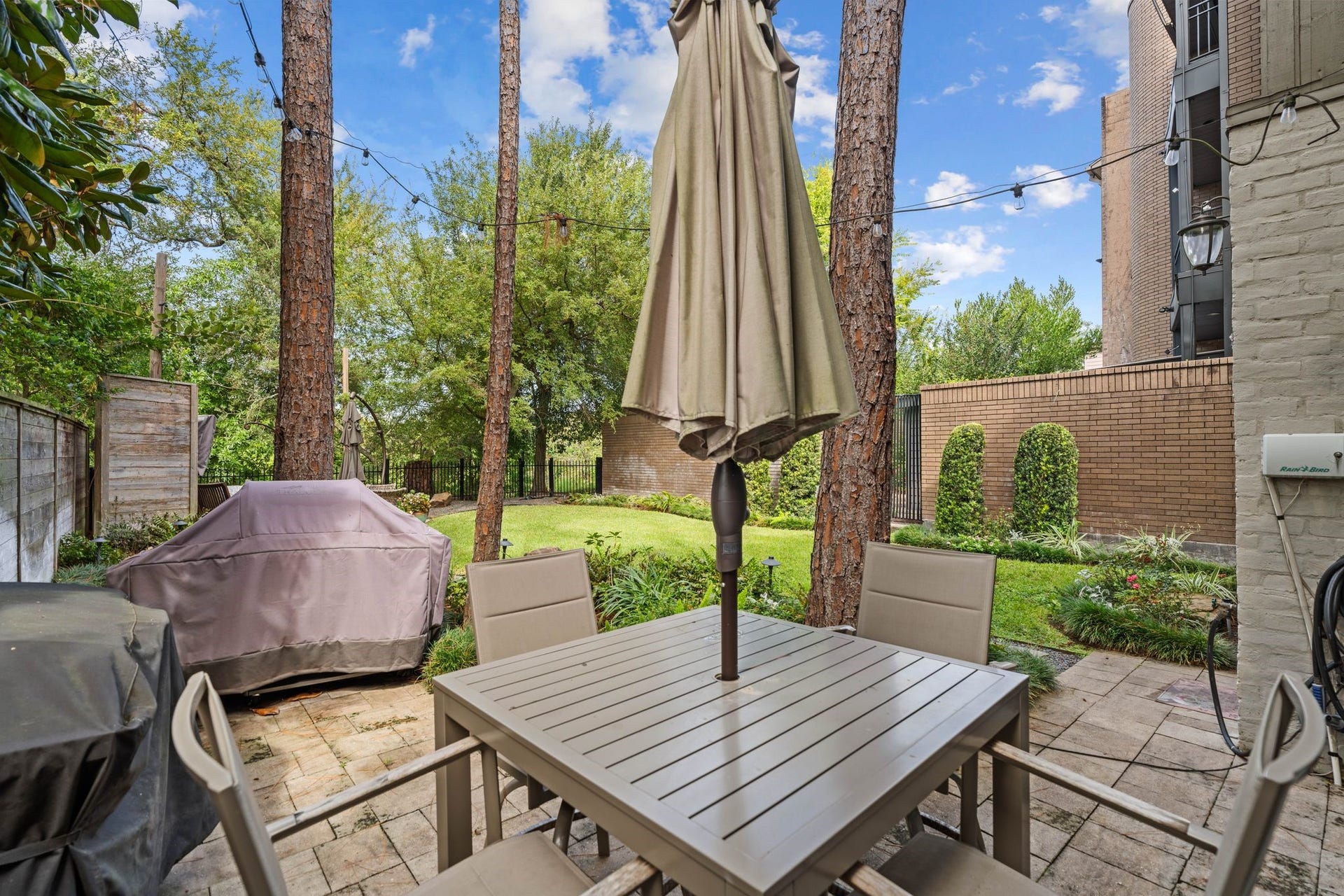 1918 Stoney Brook Drive, Houston, TX 77063 The patio beside the home provides an inviting setting for outdoor dining and grilling beneath mature trees.